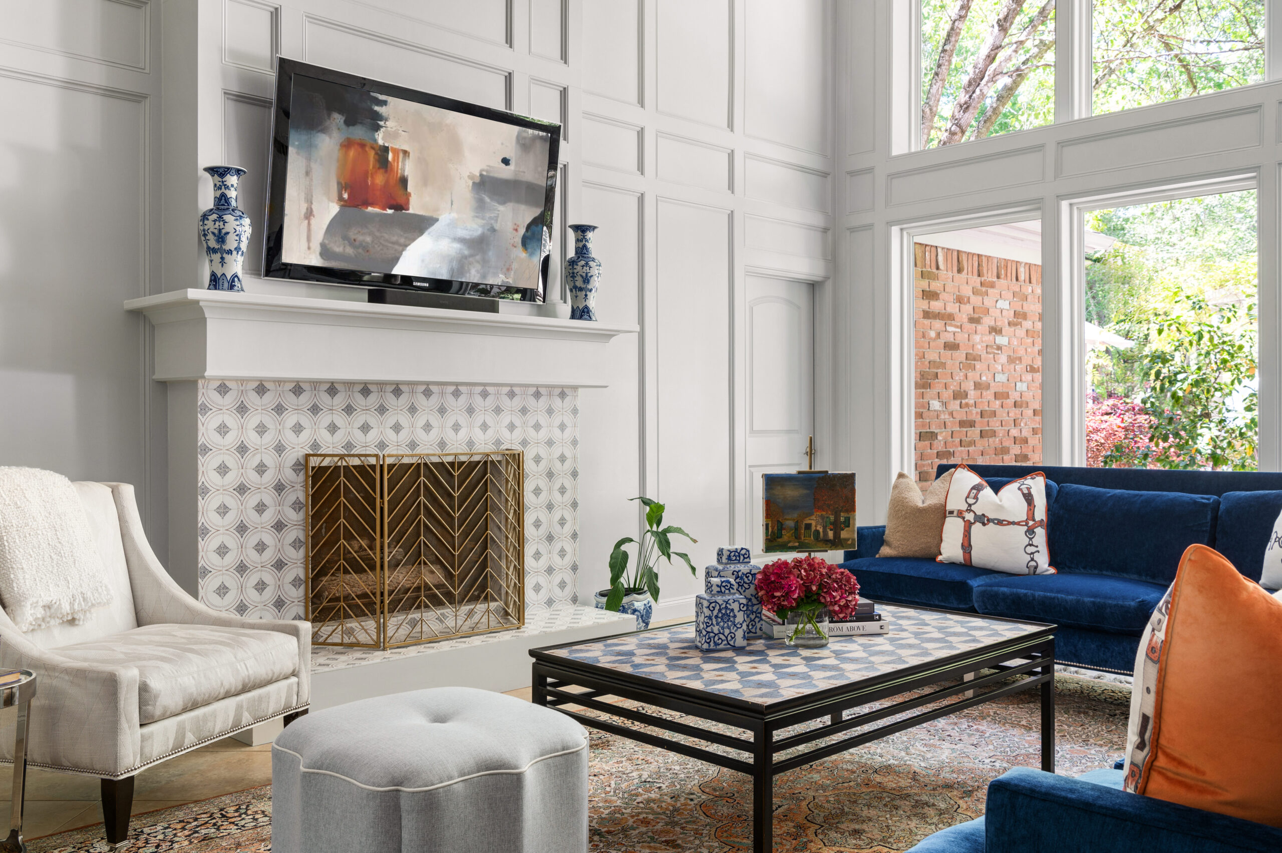 Stunning living room interior design with a fireplace, tv, and a blue velvet couch