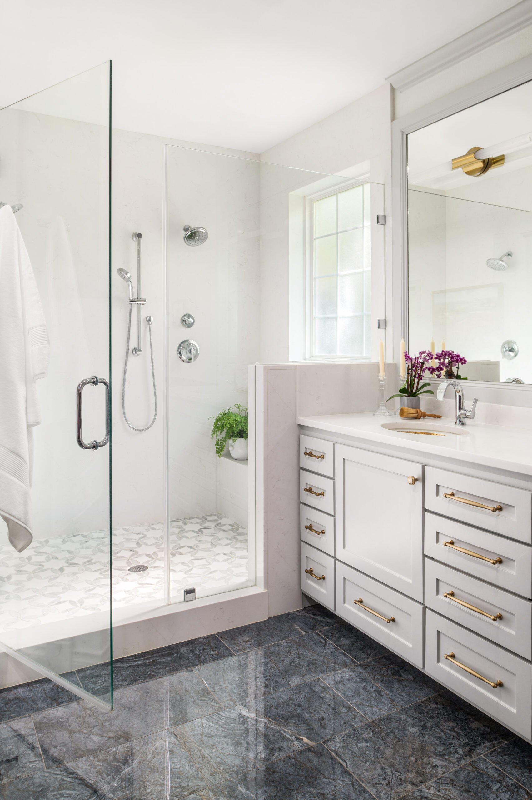 Modern bathroom interior with gray tiled flooring, a big bathtub and shower