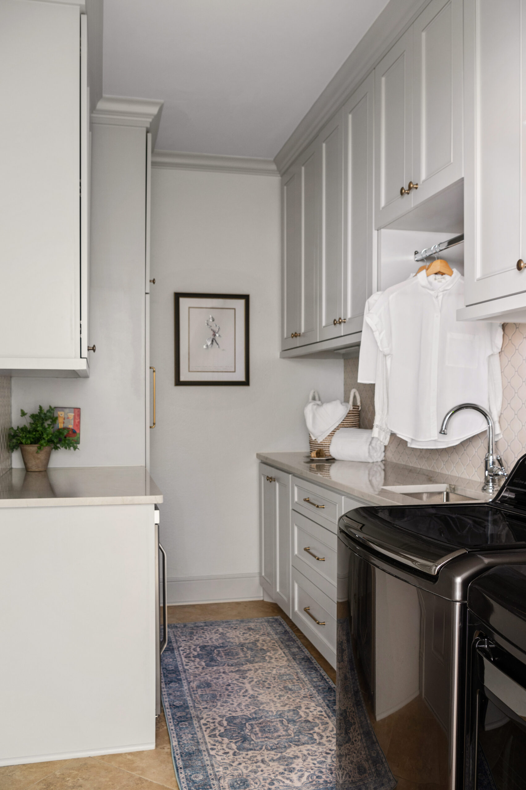 Laundry room interior design with white cabinets and a black washer and dryer