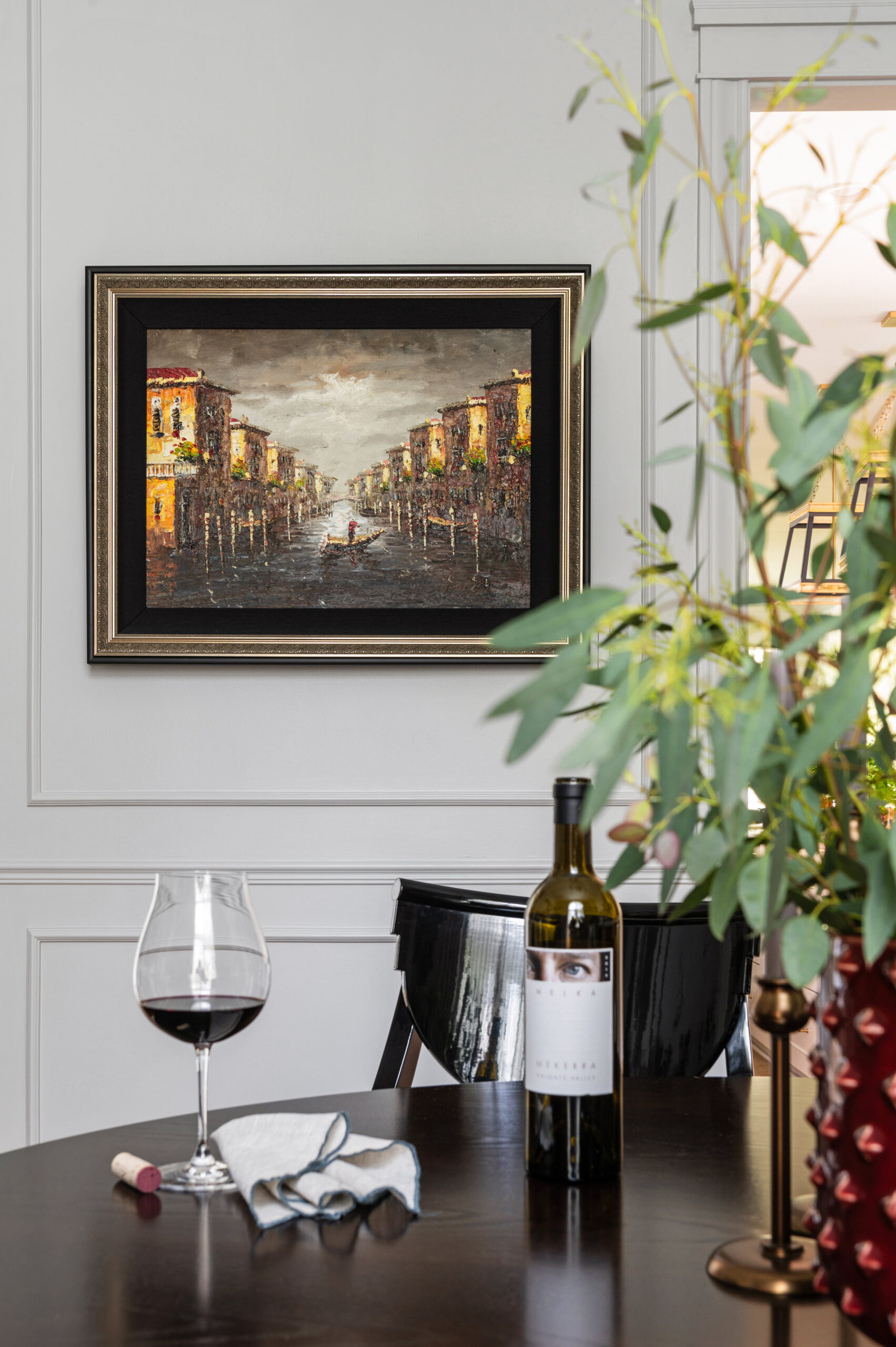 Round wooden dining room table with wine glass and wine bottle