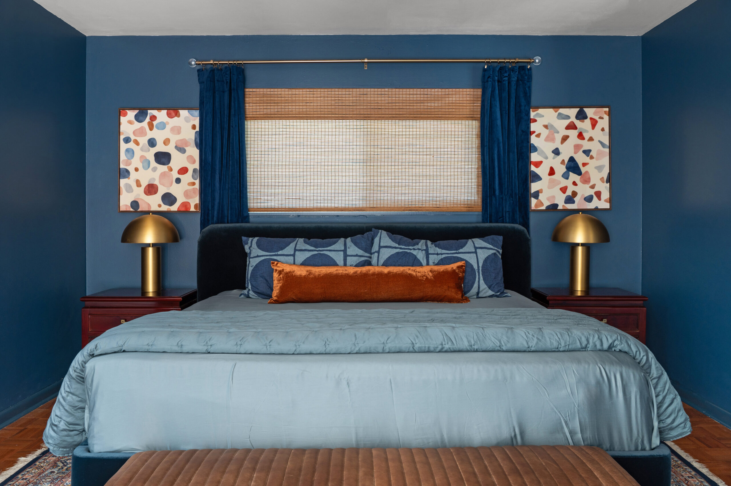 cozy, sexy, and colorful interior design of a master bedroom with blue painted walls and blue sheets