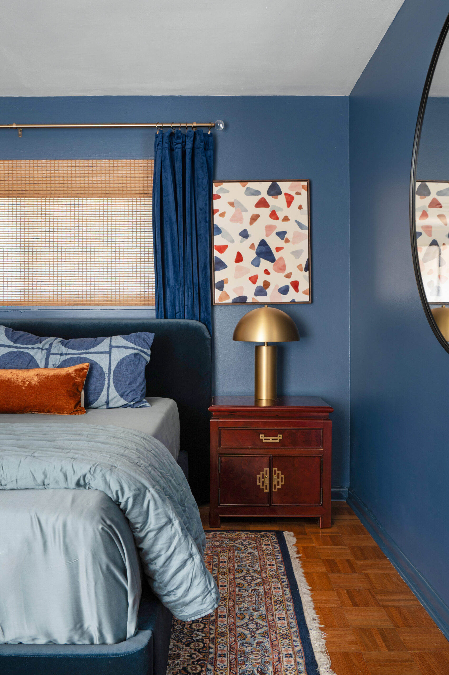 cozy, sexy, and colorful interior design of a master bedroom with blue painted walls and blue sheets