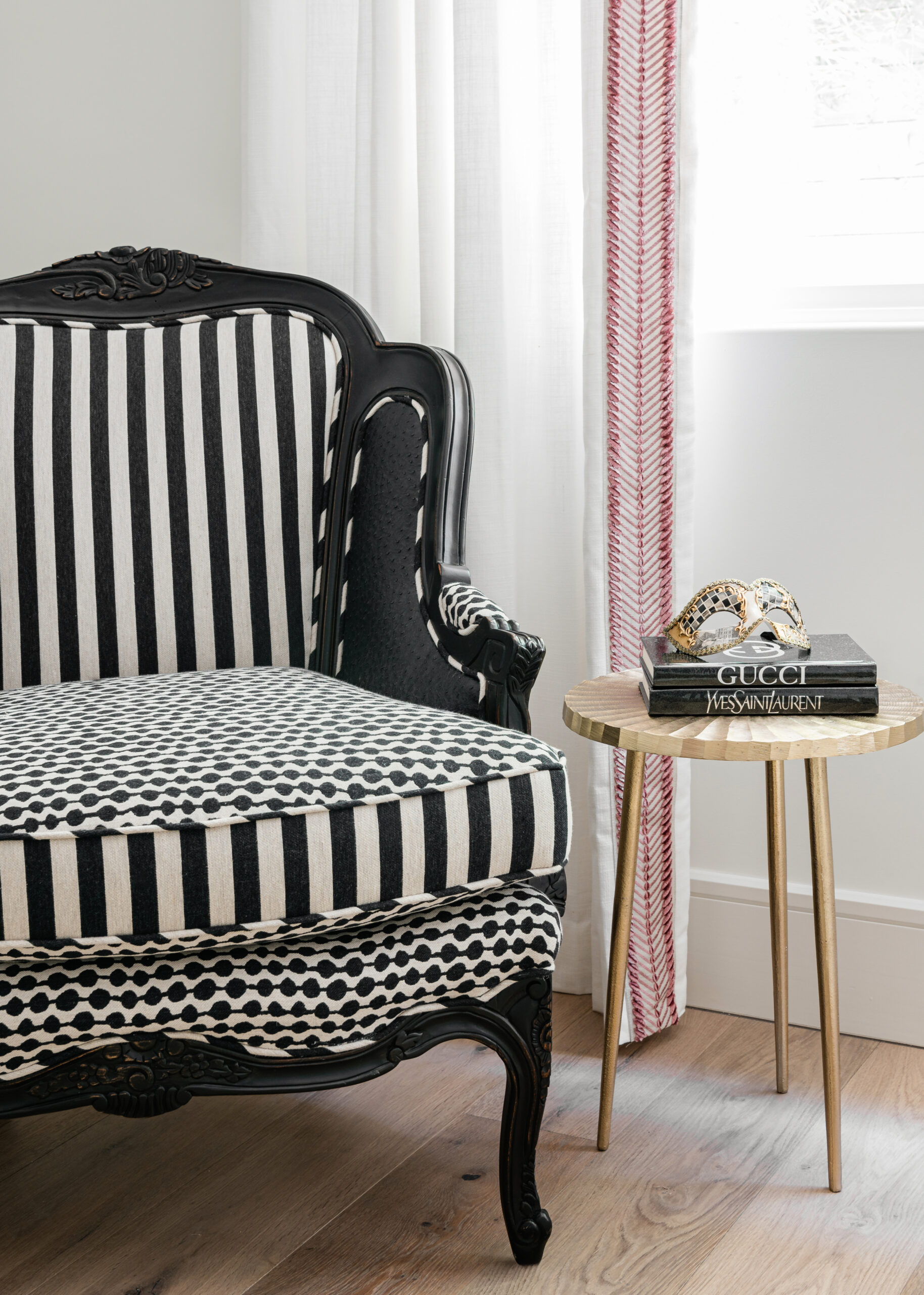 Striped accent chair with a chic side table: A stylish sitting area in a modern Texas interior design featuring a striped armchair paired with a sleek side table and minimal decor.