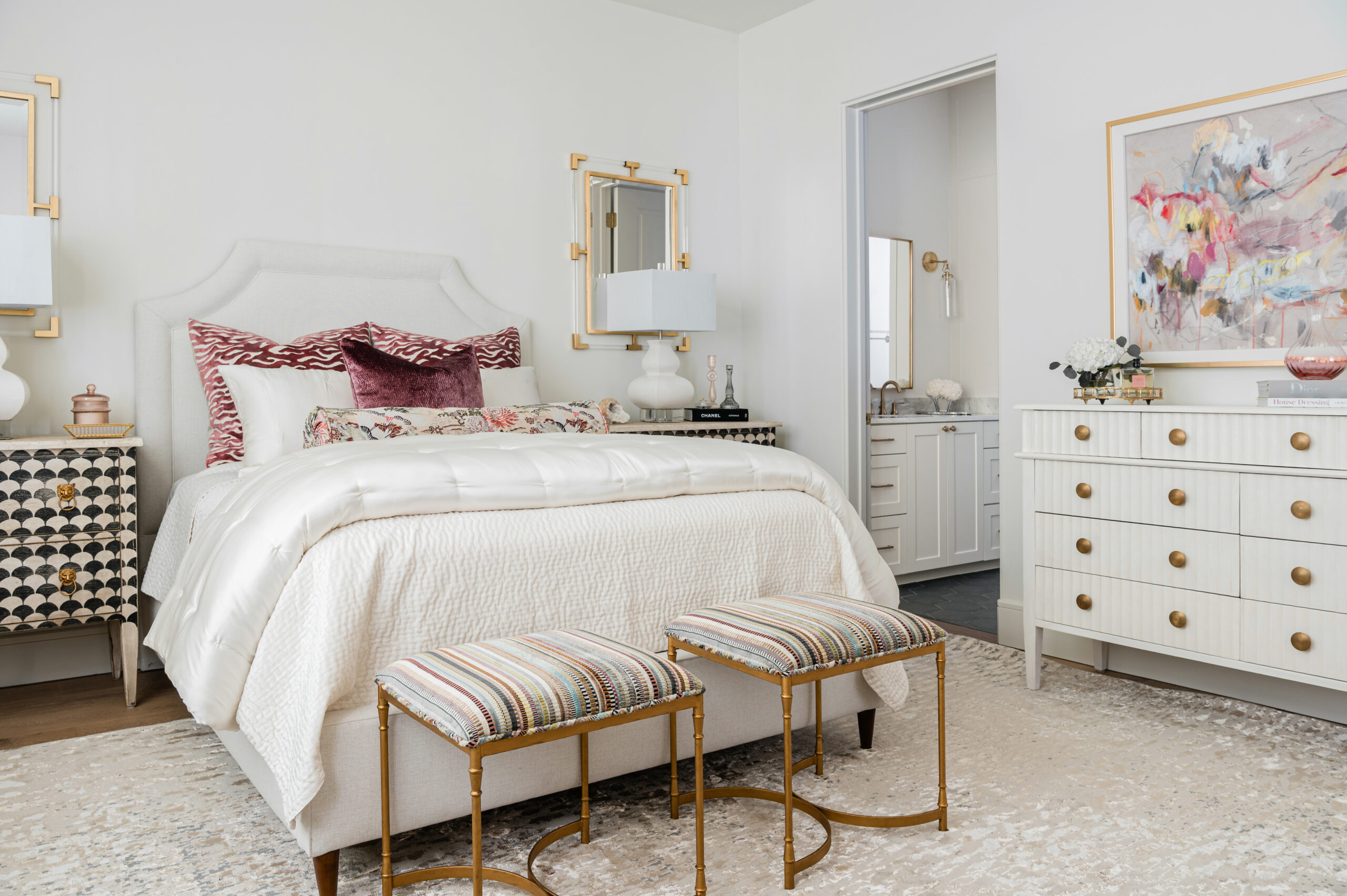 Luxurious bed with textured pillows and headboard: A cozy, modern Texas interior design bedroom with plush bedding, textured throw pillows, and a tufted headboard, all set against a light, airy backdrop.