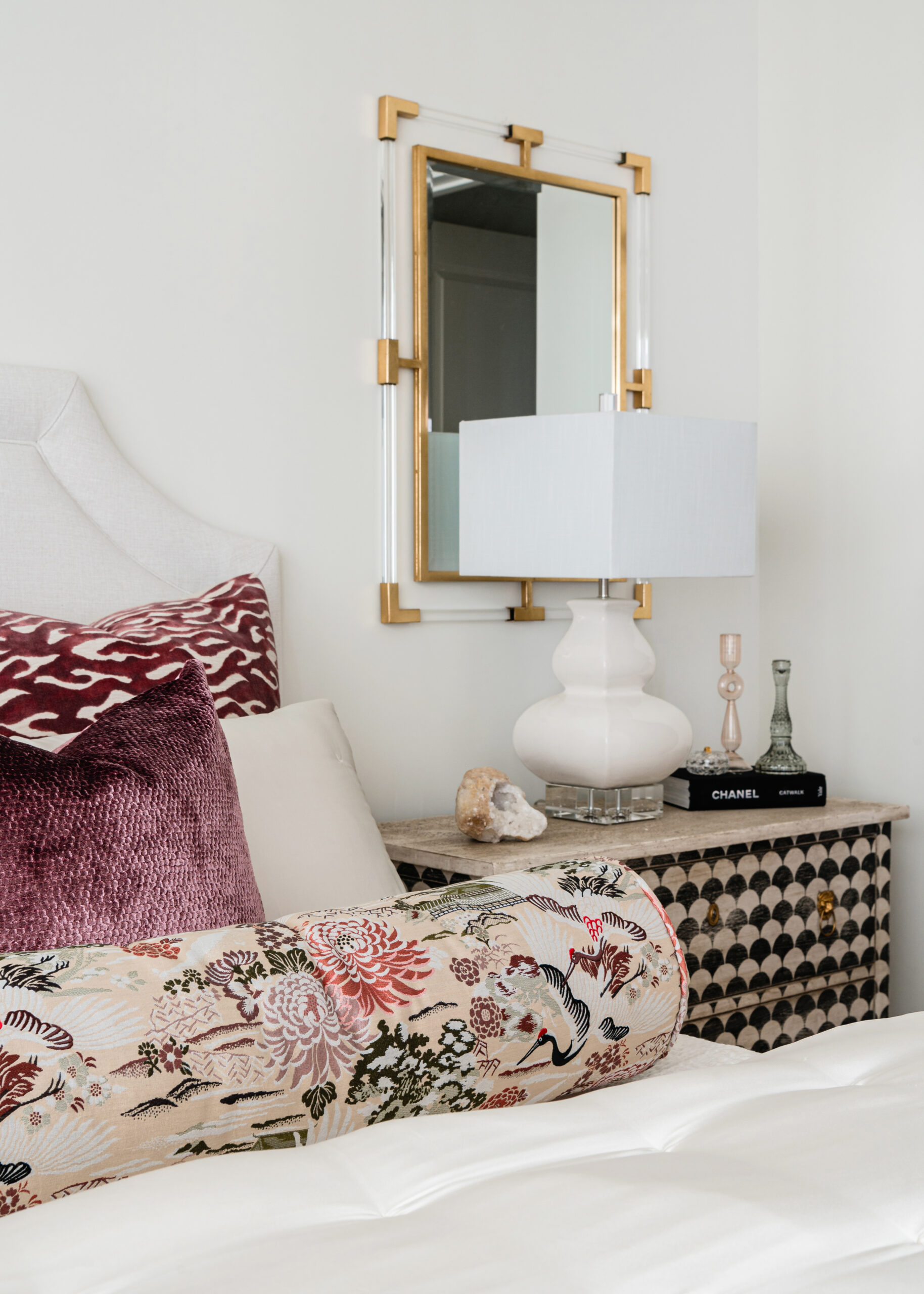 A cozy bedroom with plush textures and patterned pillows, showcasing vibrant textiles and attention to detail characteristic of Texas interior design.