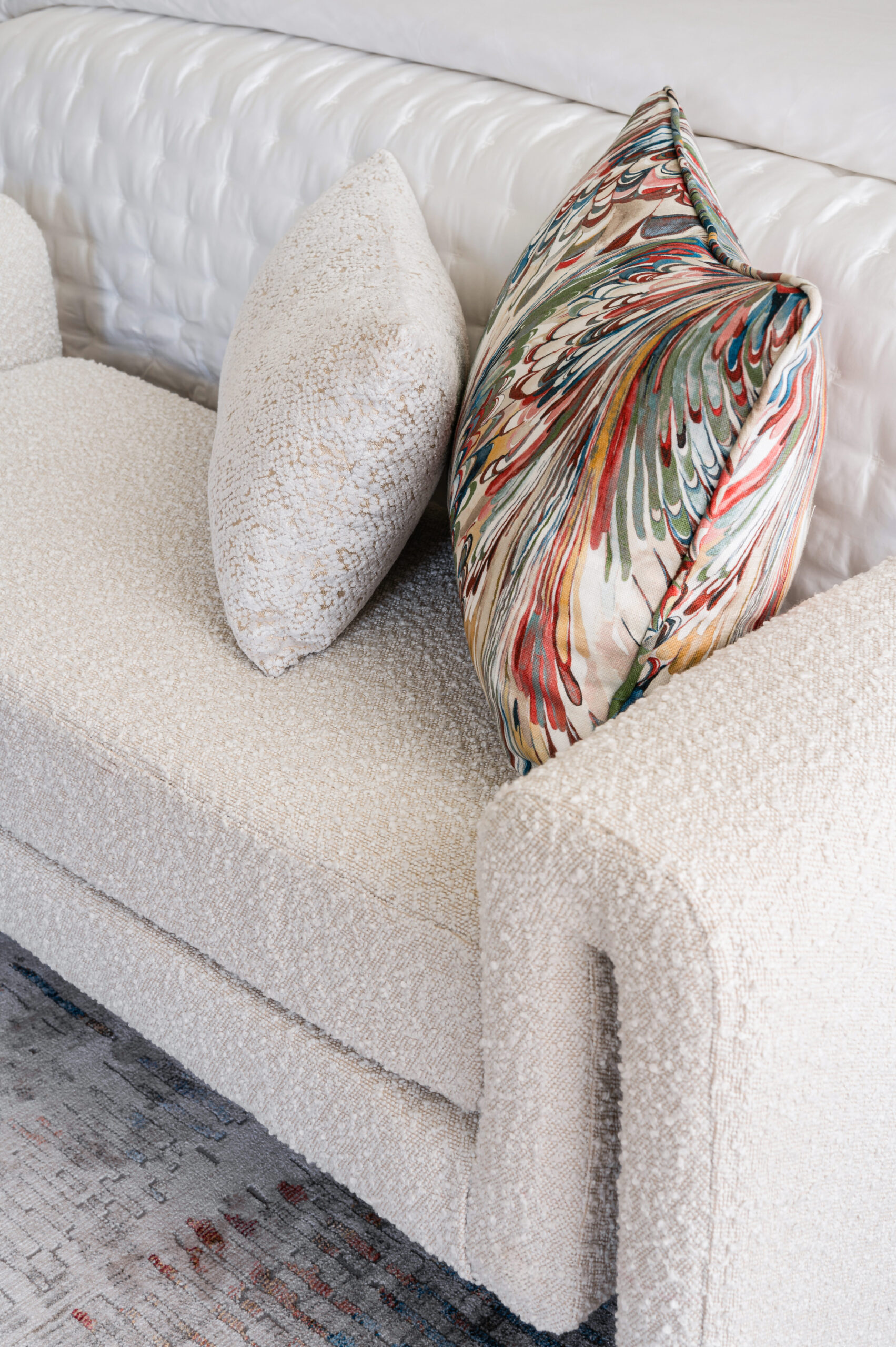 A cream-colored couch adorned with textured and colorful throw pillows, demonstrating the tactile and vibrant elements of Texas interior design.