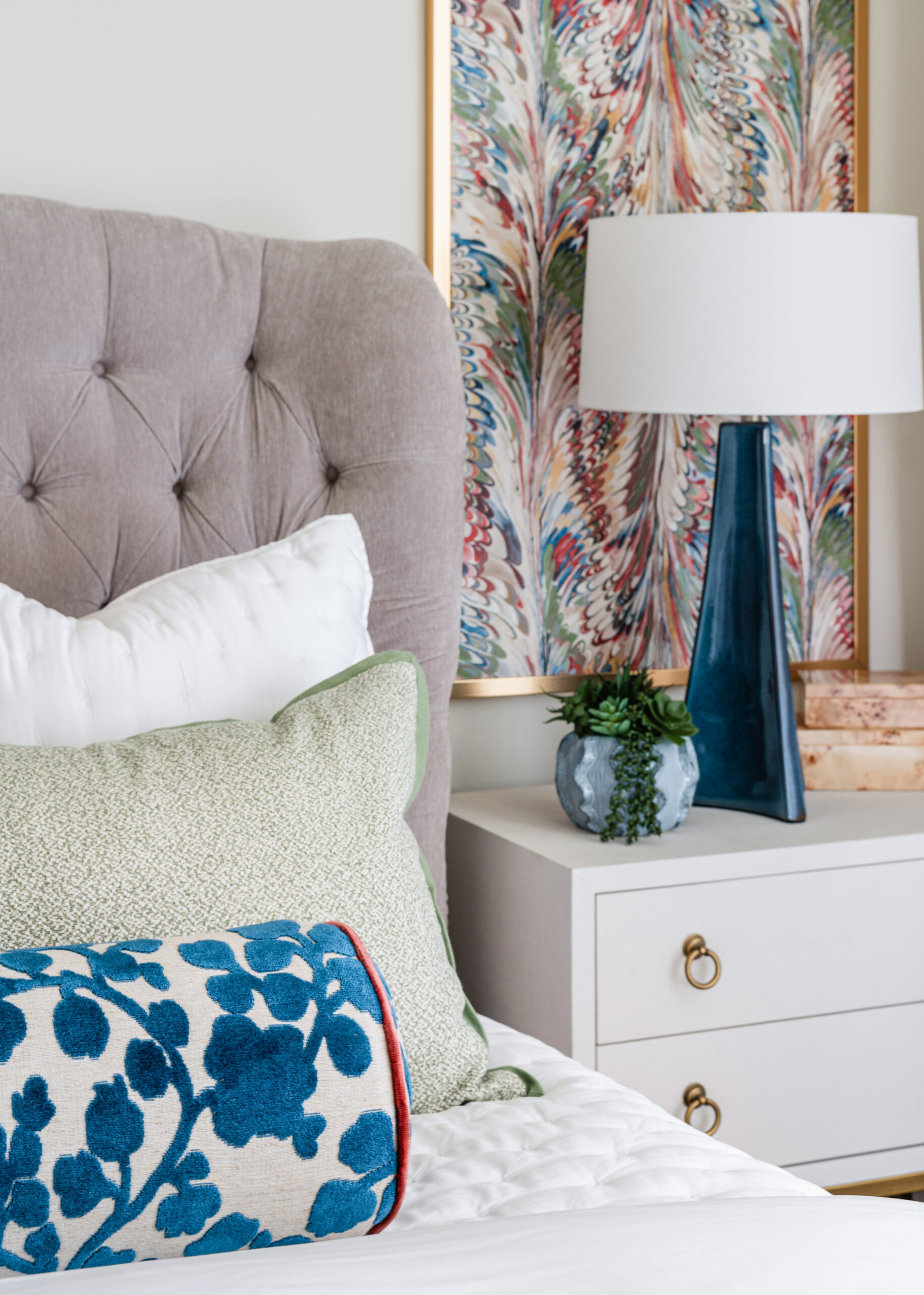 A cozy bedroom with plush textures and patterned pillows, showcasing vibrant textiles and attention to detail characteristic of Texas interior design.