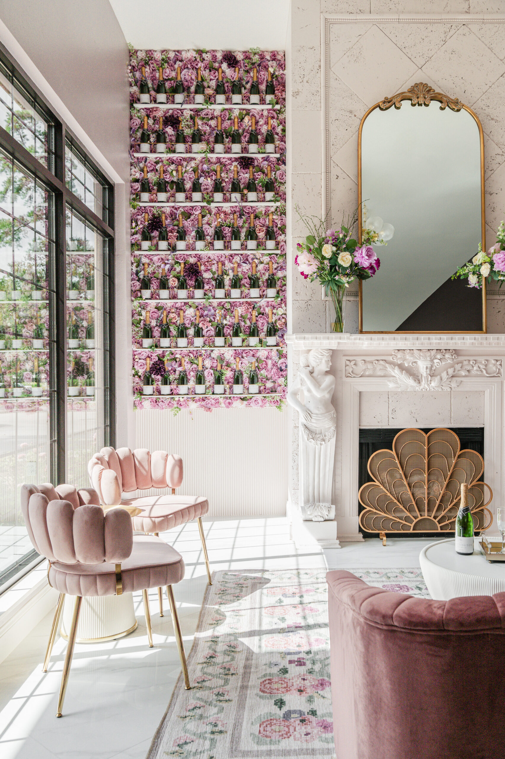 A beautifully decorated entrance area of a bridal boutique, featuring a vintage telephone booth adorned with a floral arrangement. Large glass doors provide a view of the outside greenery.