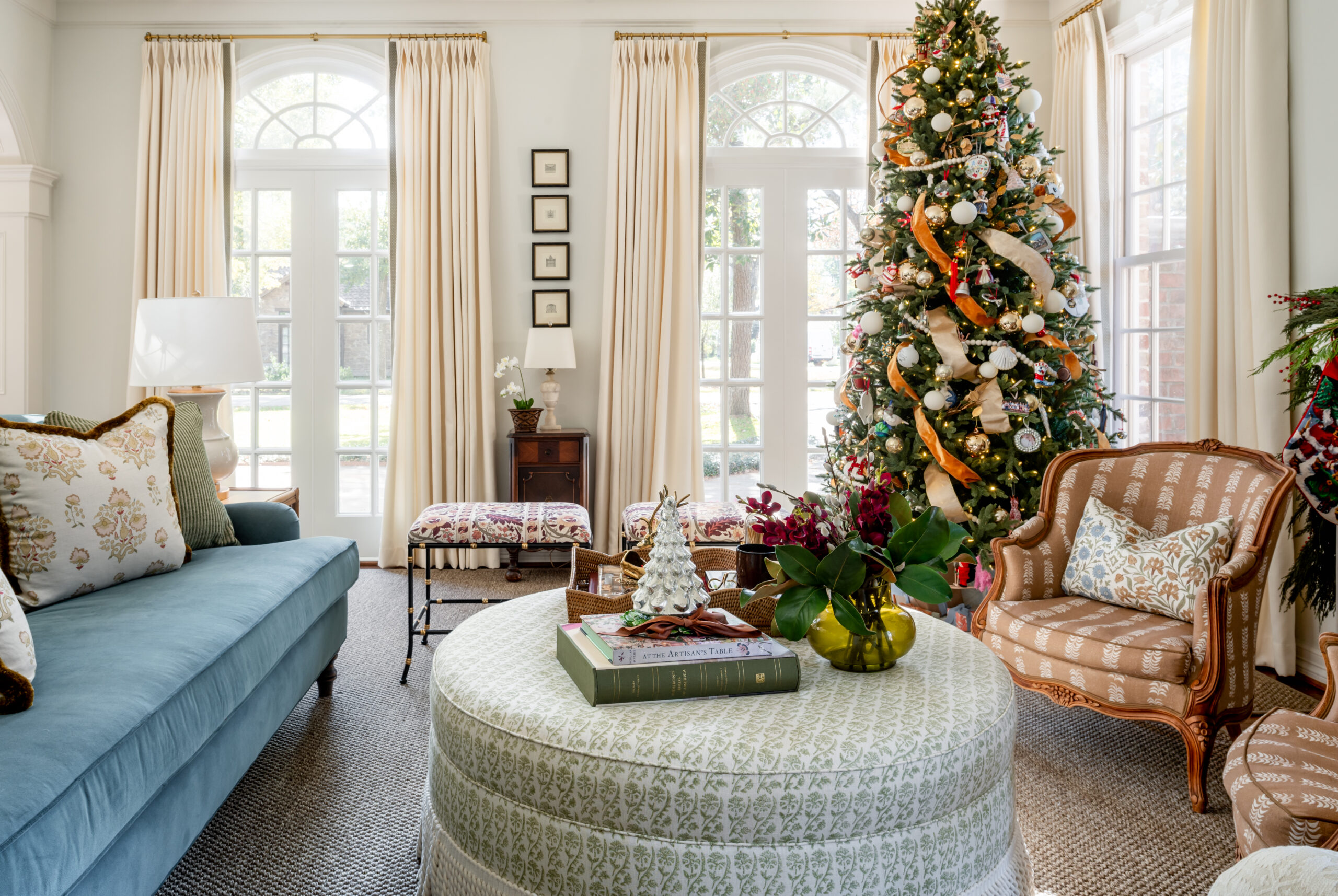 A cozy living room with a decorated Christmas tree and seasonal interior design elements, including a festive coffee table, colorful ornaments, and holiday-themed floral arrangements