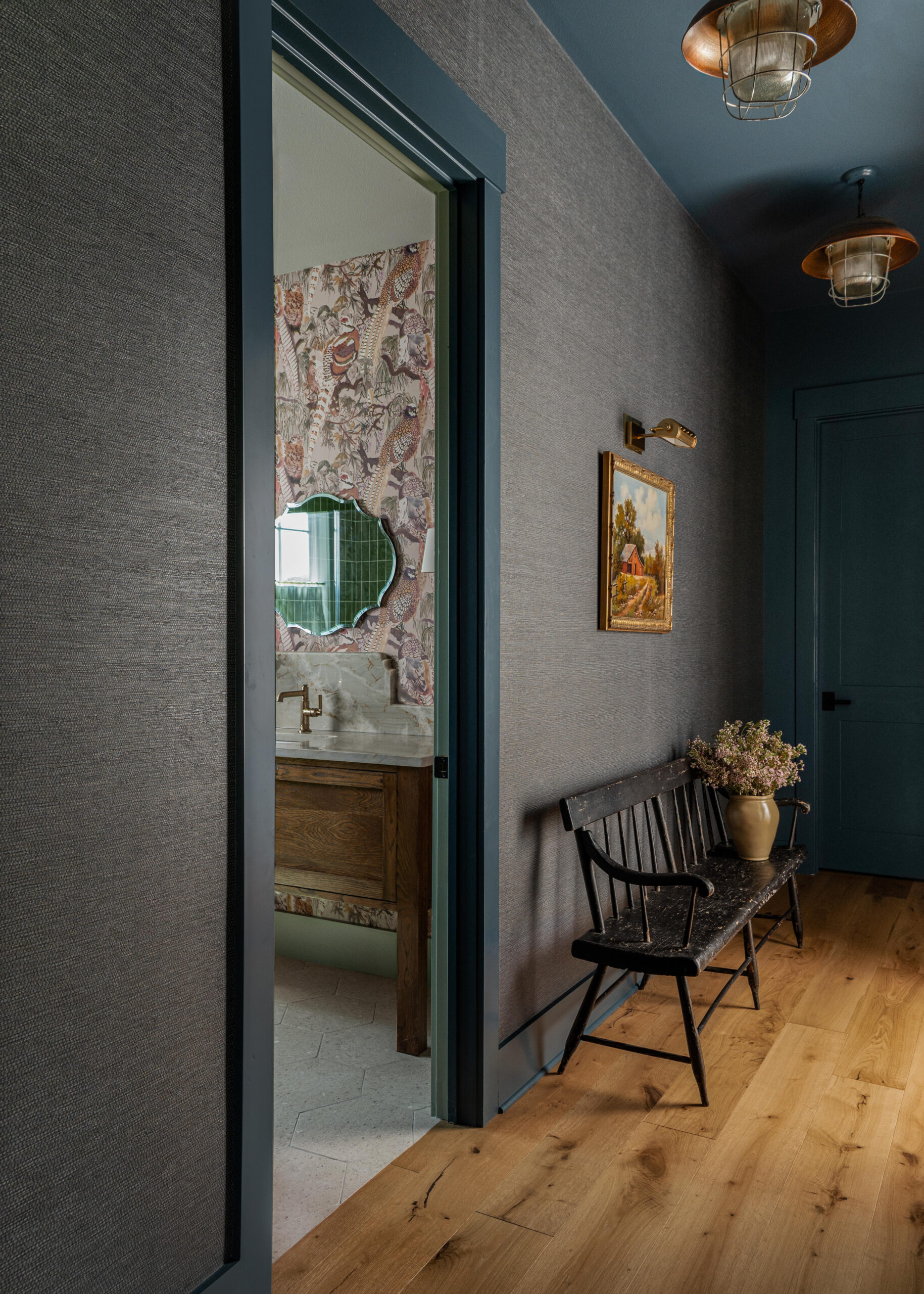 Elegant hallway leading to a vintage-styled bathroom with detailed wallpaper and custom design elements that blend modern and classic interior styles.