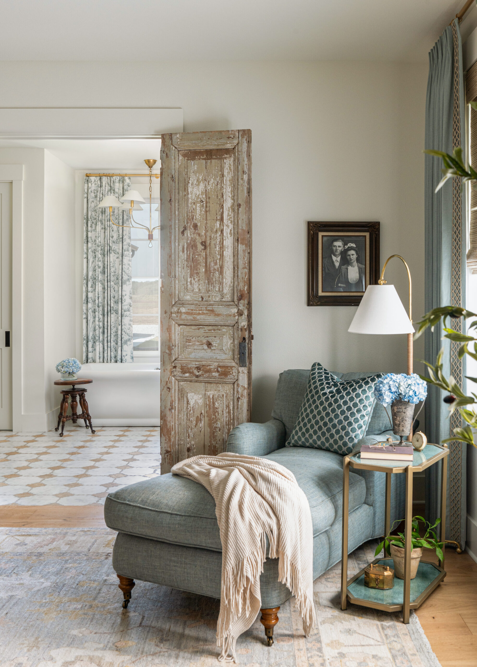 Custom interior design living room featuring a cozy chair, natural light, and rustic details with a touch of vintage charm.