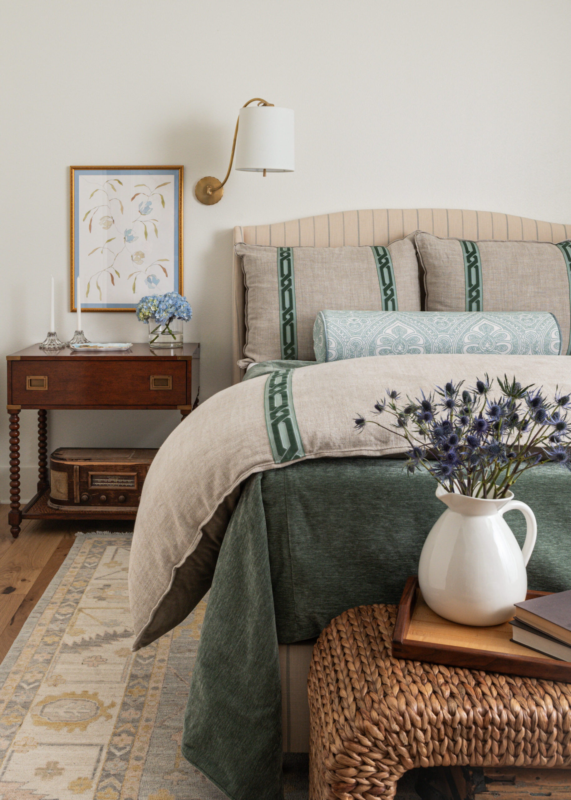 Custom interior design bedroom with luxurious bedding, vintage side tables, and a beautiful mix of textures and colors.