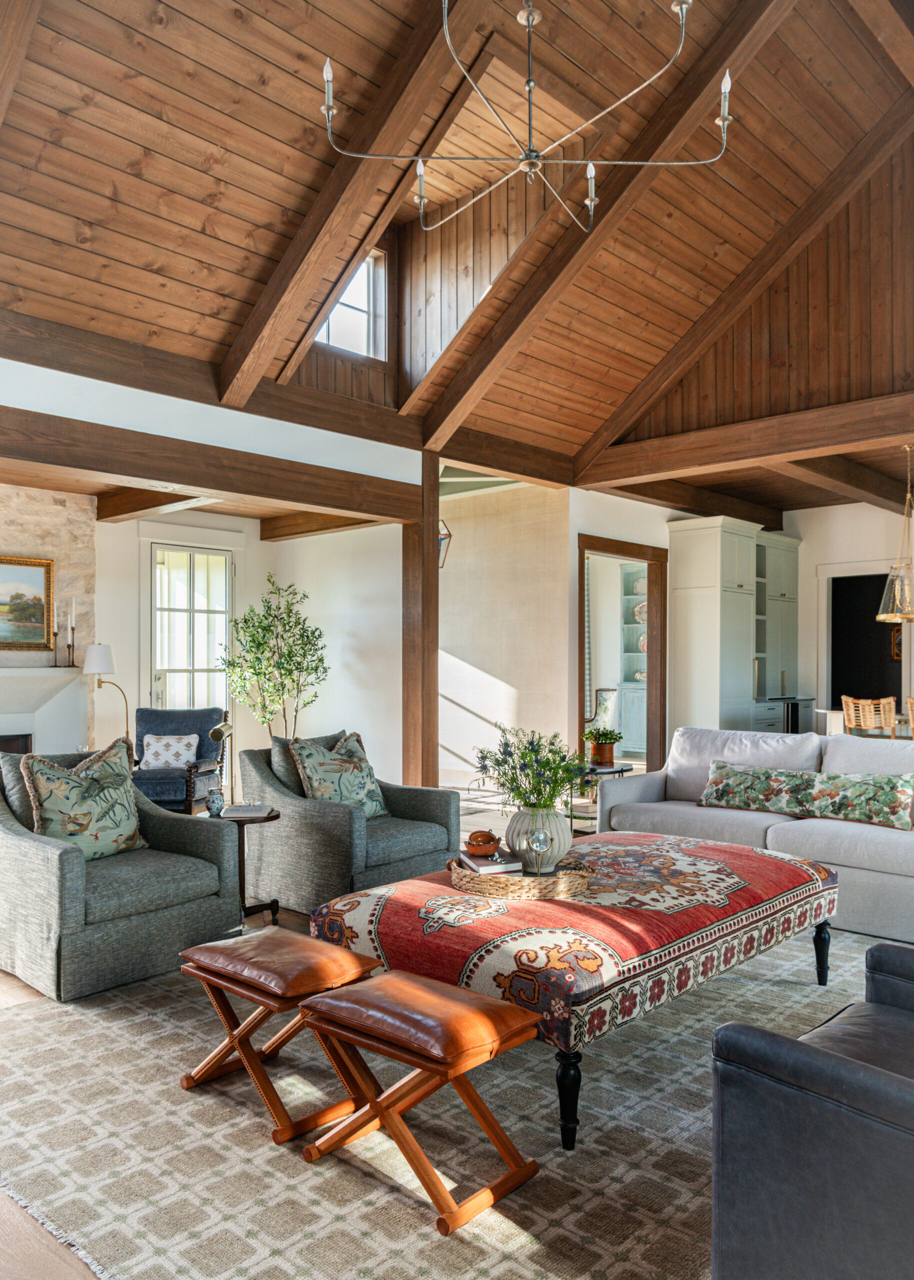 Spacious living room with custom interior design, showcasing a mix of vintage and contemporary pieces under a wooden ceiling.