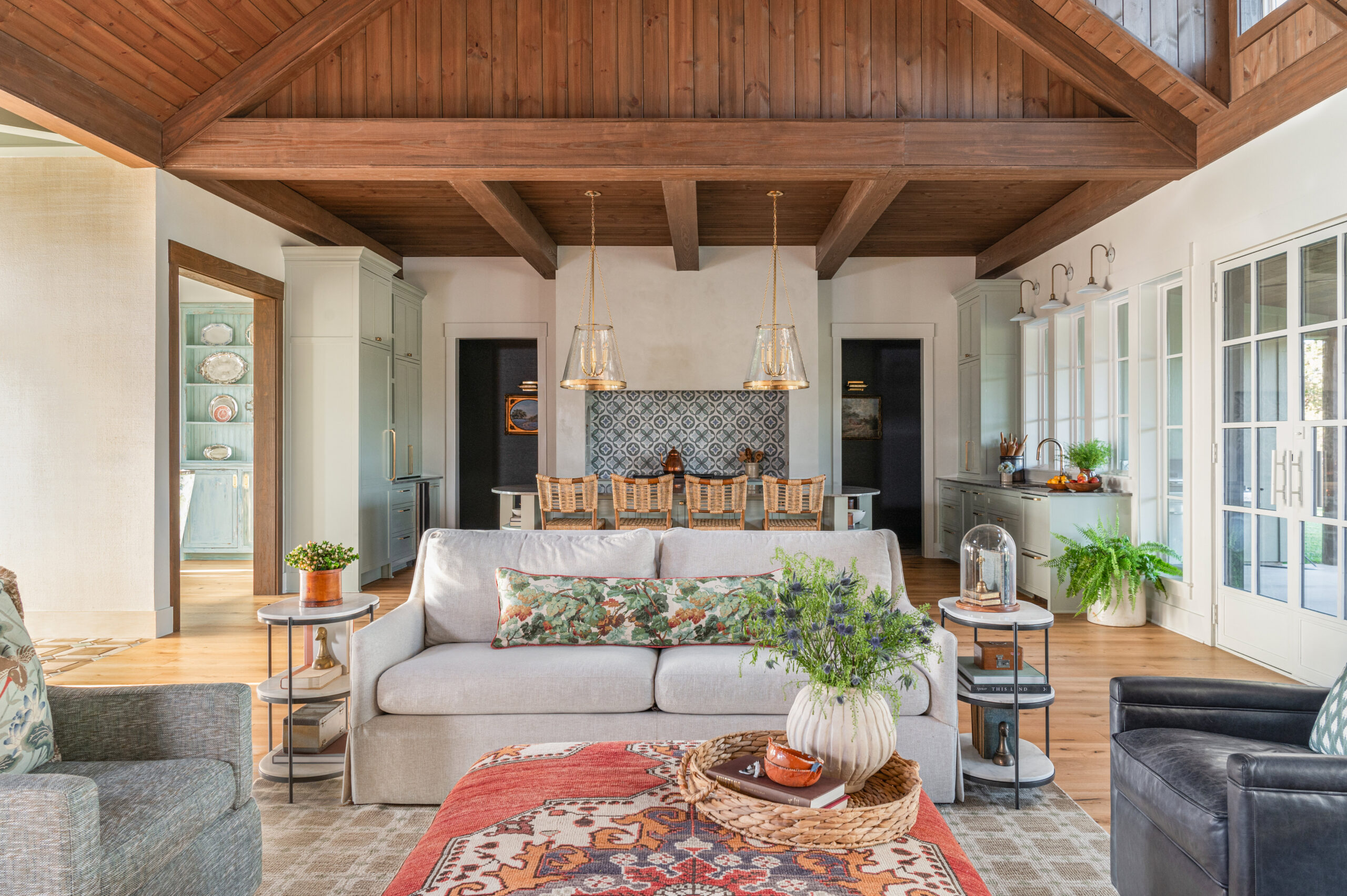 Spacious living room with custom interior design, showcasing a mix of vintage and contemporary pieces under a wooden ceiling.