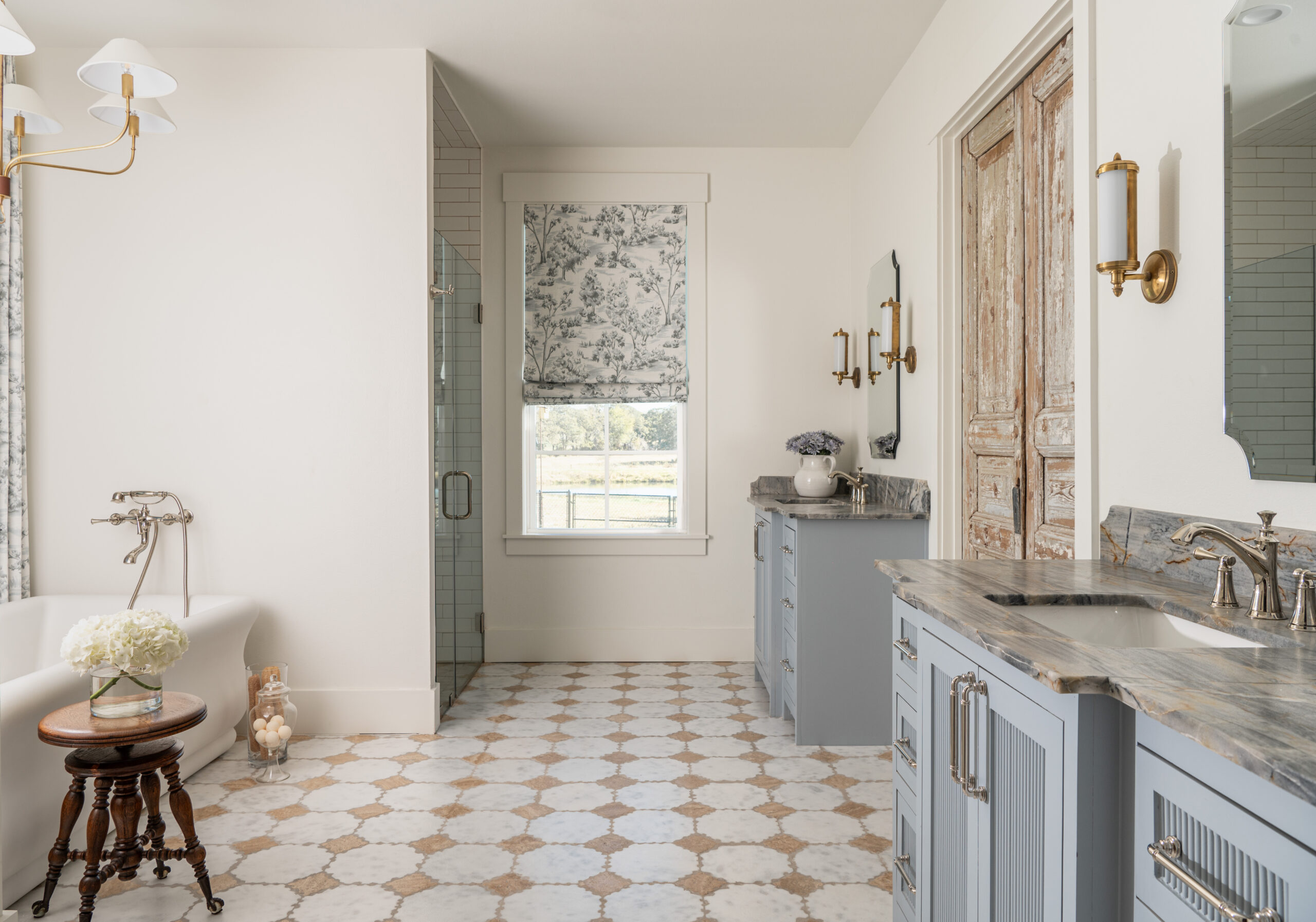 Elegant bathroom vanity area featuring custom interior design with marble countertops, chic light fixtures, and beautiful flowers.