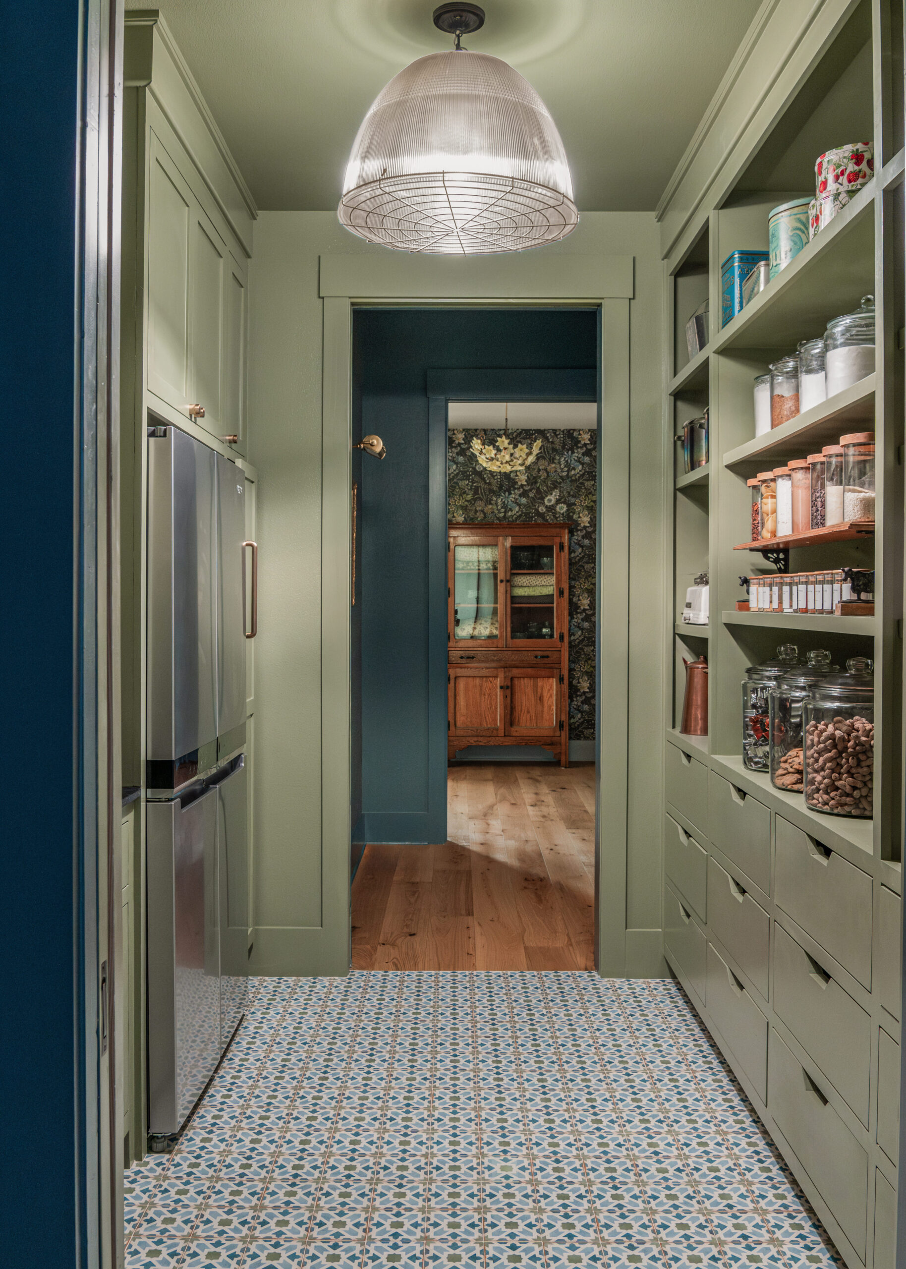 Kitchen pantry with custom built-in shelves, filled with organizational tools and textures that elevate the custom interior design of the entire space.