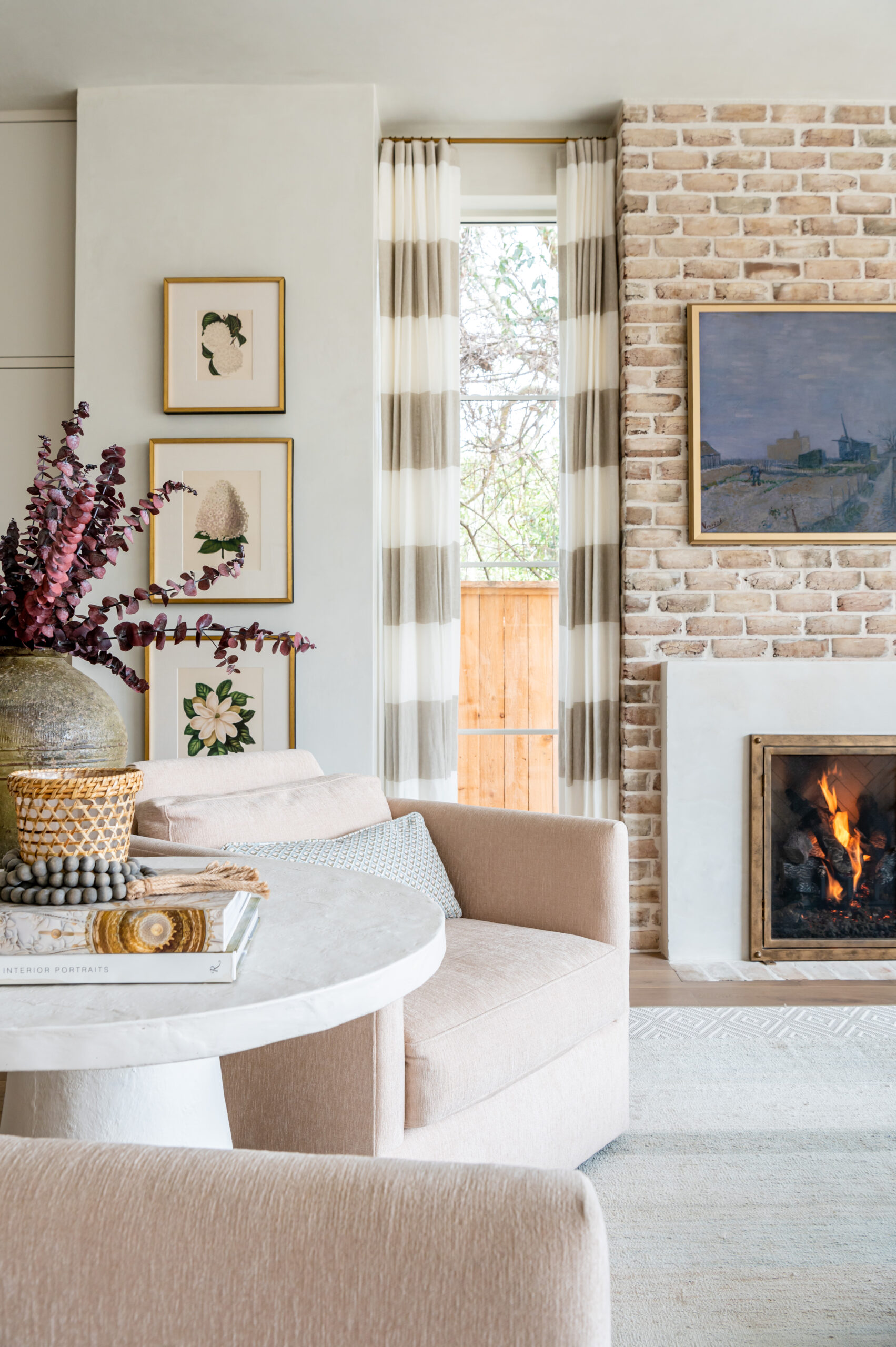 Light-filled living room with a cozy, elegant seating area: A stylish living room featuring a neutral color palette with soft curtains and a welcoming fireplace, highlighting the mastery of interior design in crafting relaxing spaces.