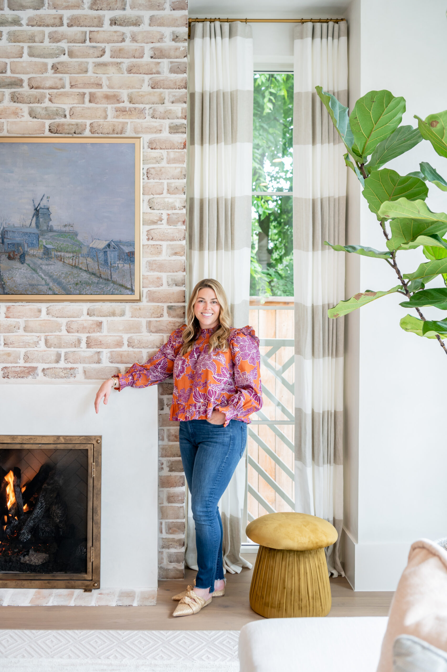 A stylish living room featuring a statement art piece, plants, and neutral-colored furniture. This space is designed with master interior design principles, incorporating elements of nature and comfort to create a cozy yet sophisticated vibe.