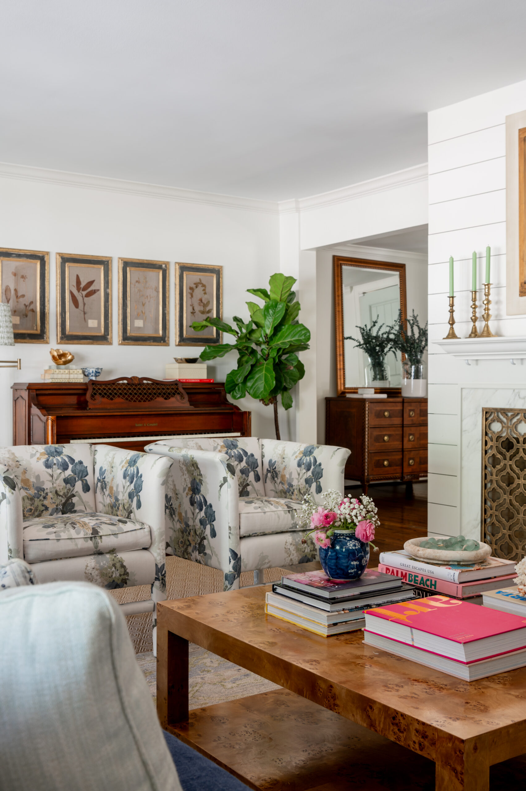 A welcoming living room featuring a harmonious blend of antique and modern furniture, colorful art, and vibrant flowers, a perfect example of how master interior design creates inviting, functional spaces.