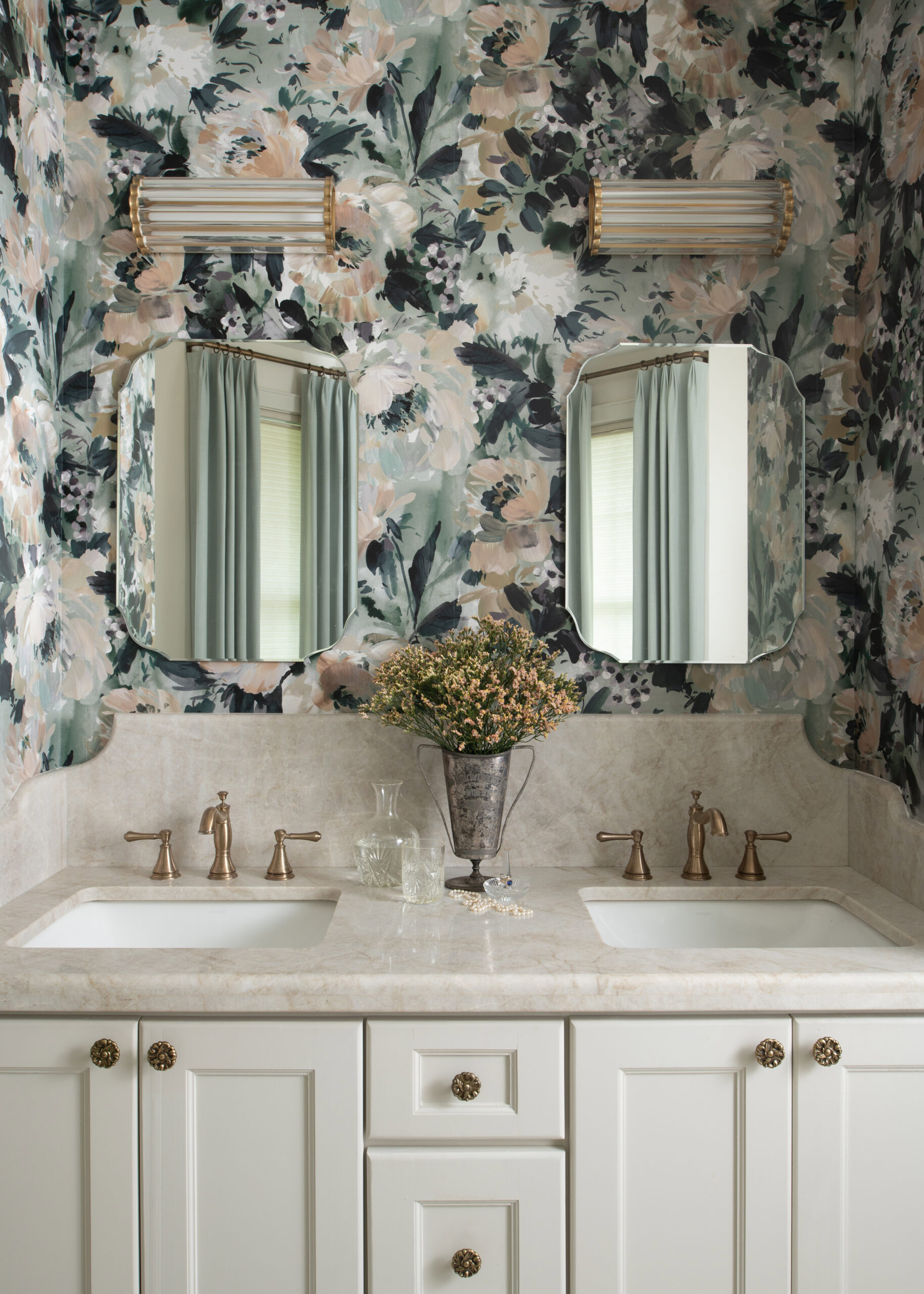 Bathroom with floral wallpaper and luxurious dual mirrors. The space embraces a timeless modern interior design that combines elegance and functionality with gold accents.