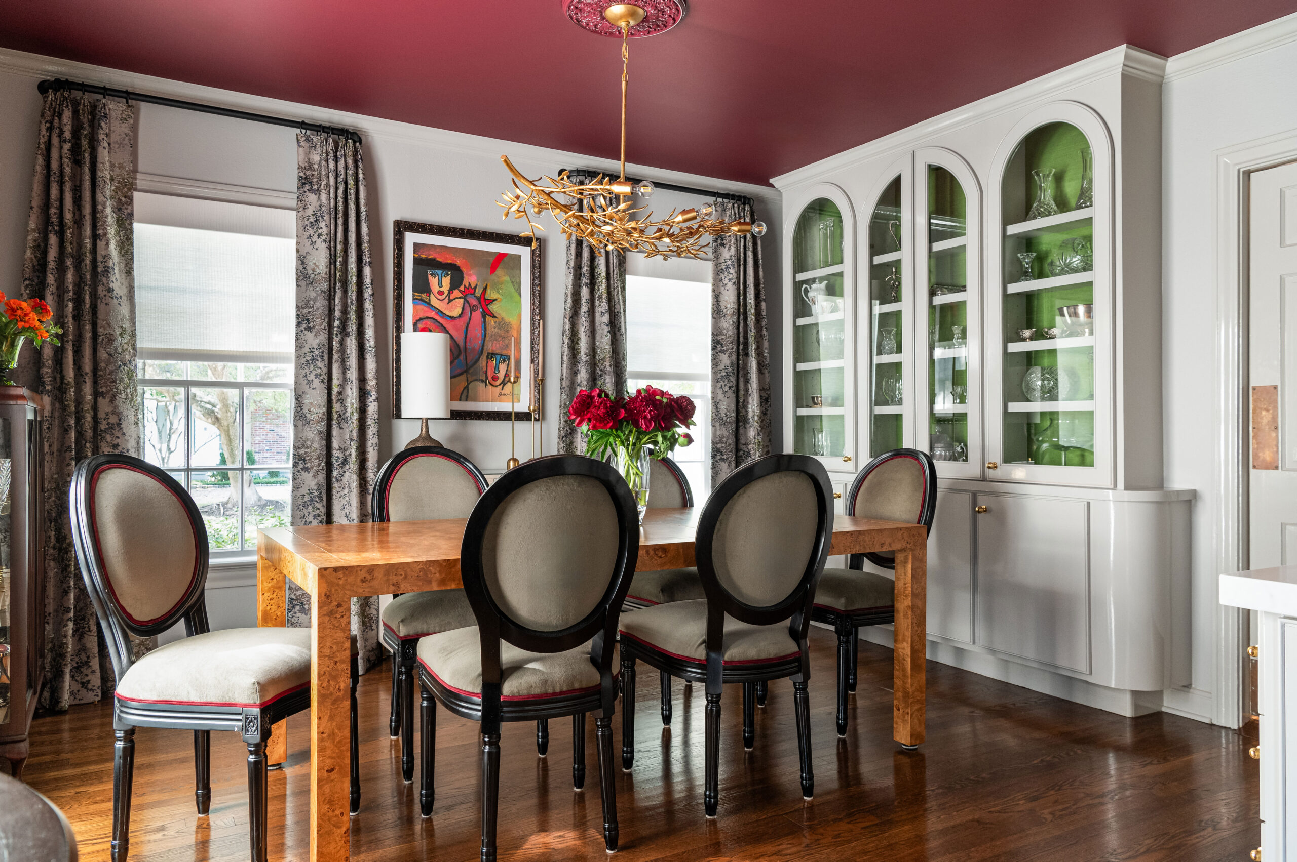 A modern dining room with a dramatic red ceiling and traditional chairs, captured beautifully in this interior design and photography shot.