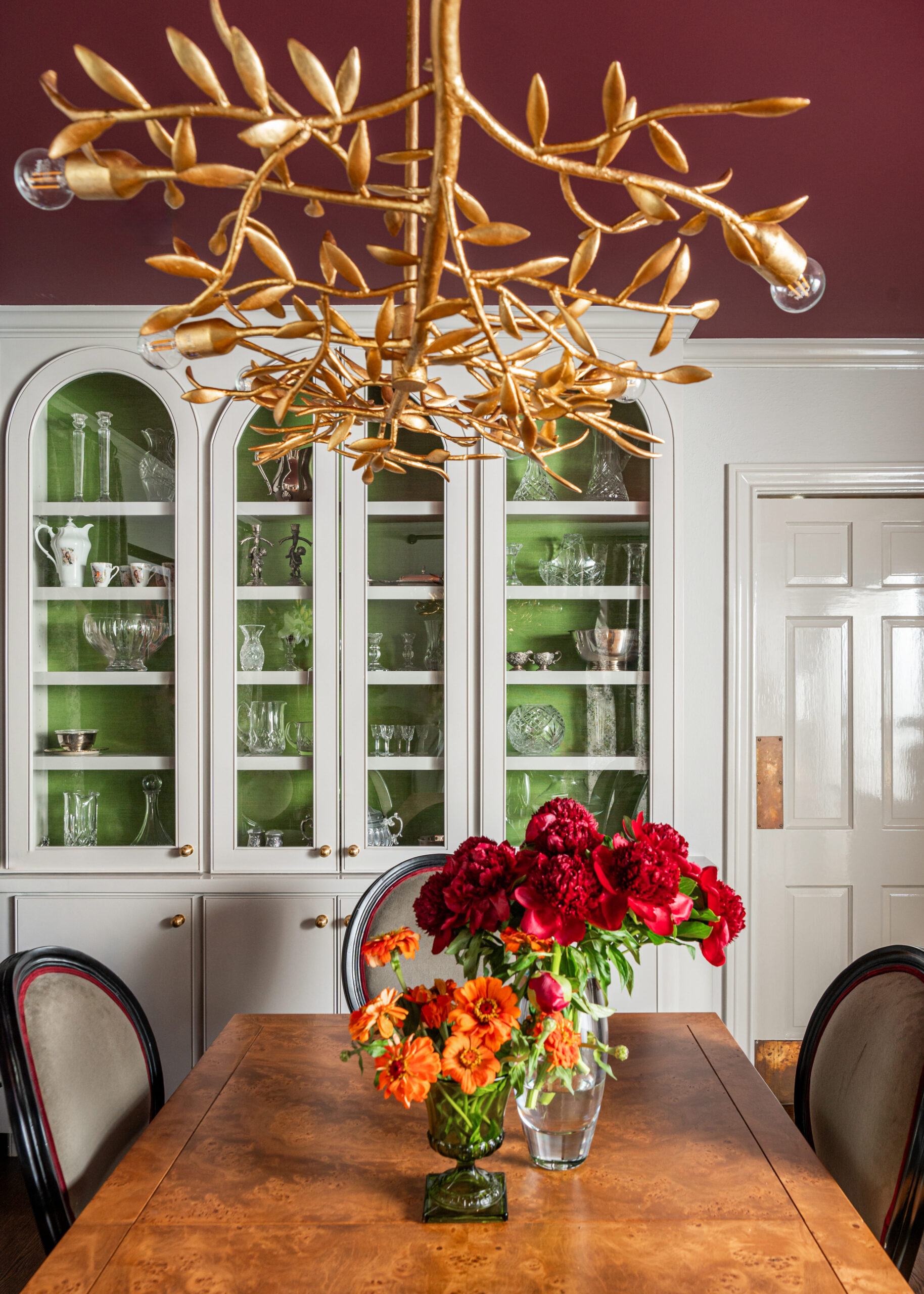 This image highlights an intricate chandelier and antique dining room set, bringing the space’s charm to life through interior design and photography.