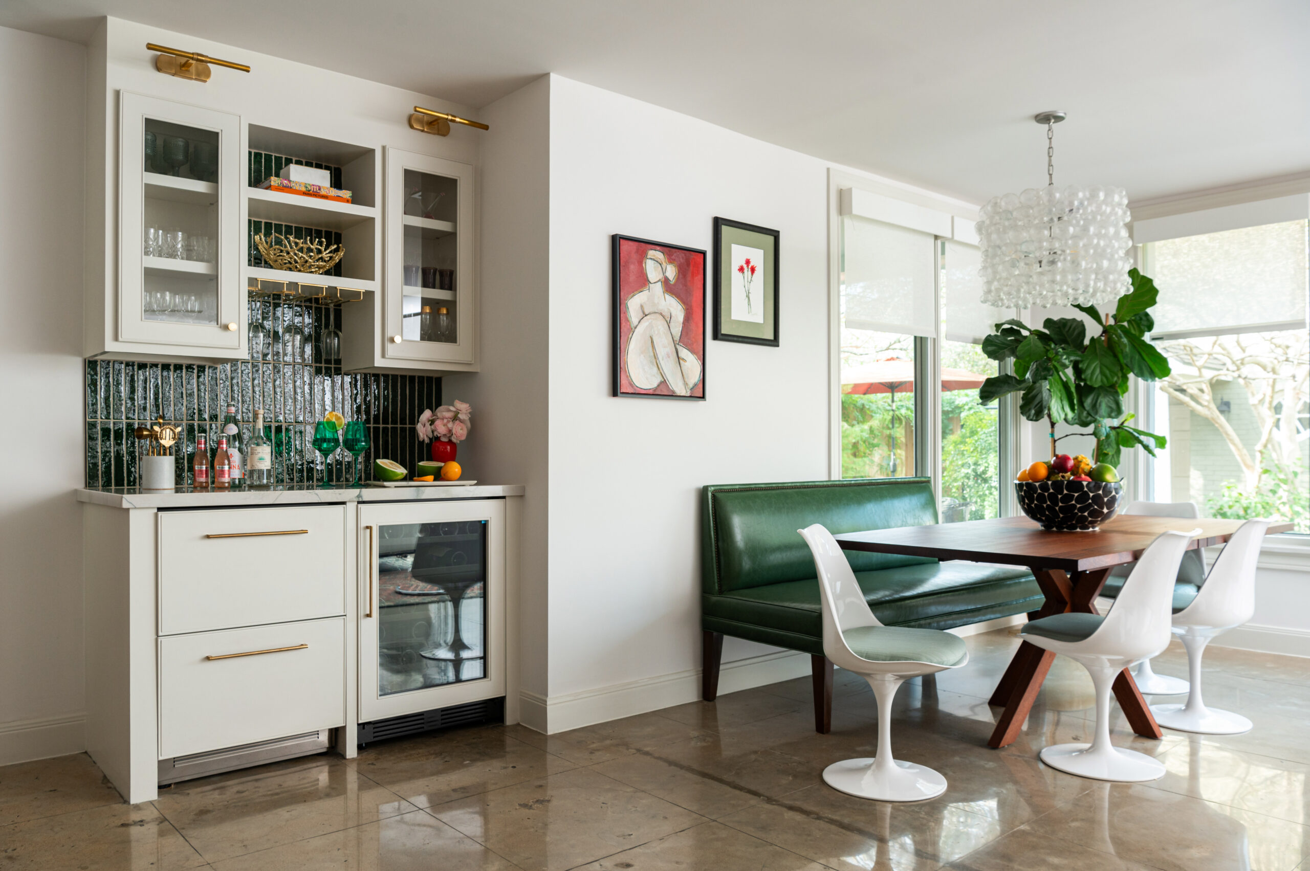 A beautifully styled dining nook with modern art and statement lighting. This interior design photograph emphasizes the striking contrast between modern and classic elements.