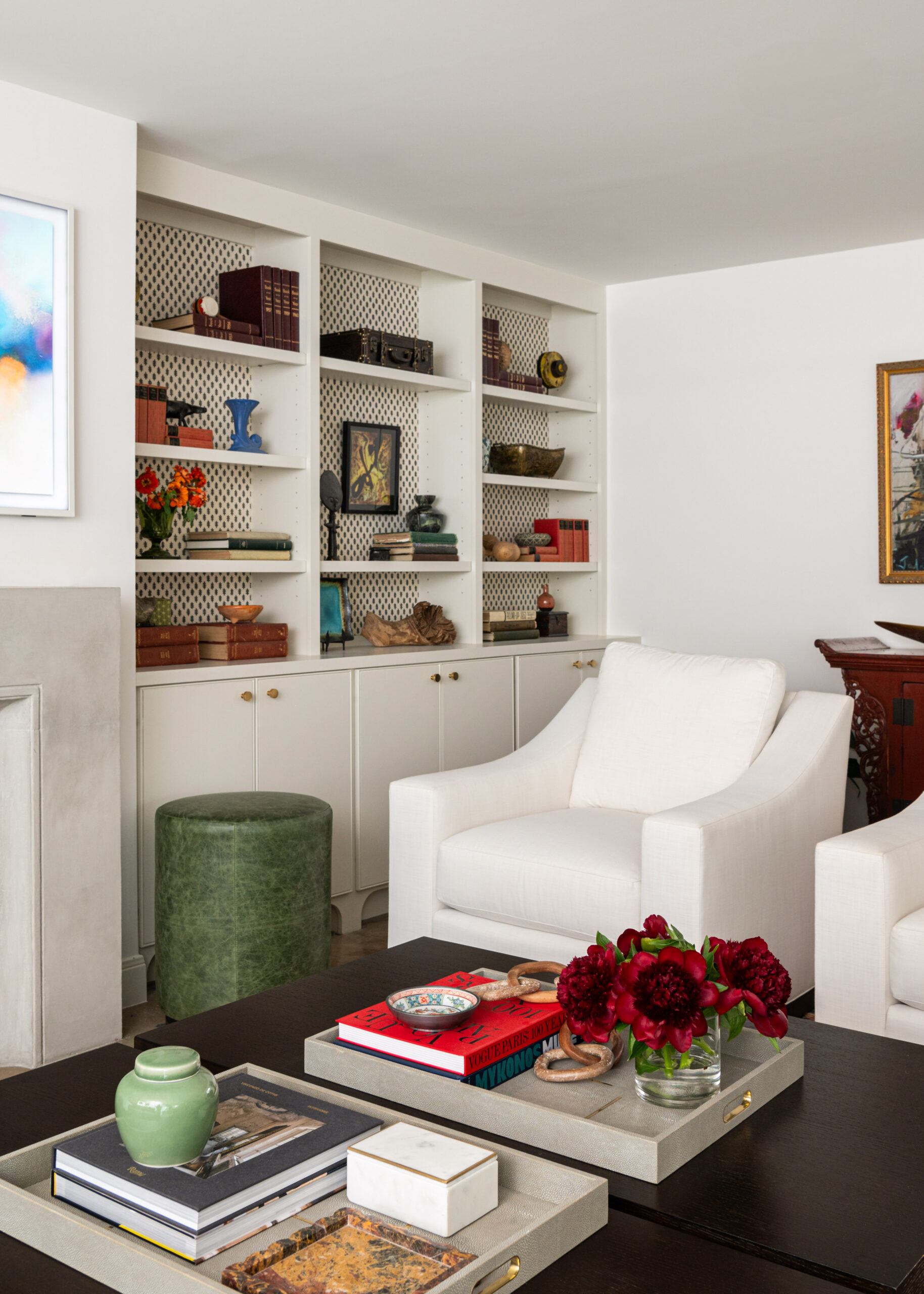 Interior design and photography showcase a cozy reading nook with white armchairs and beautifully styled shelves.