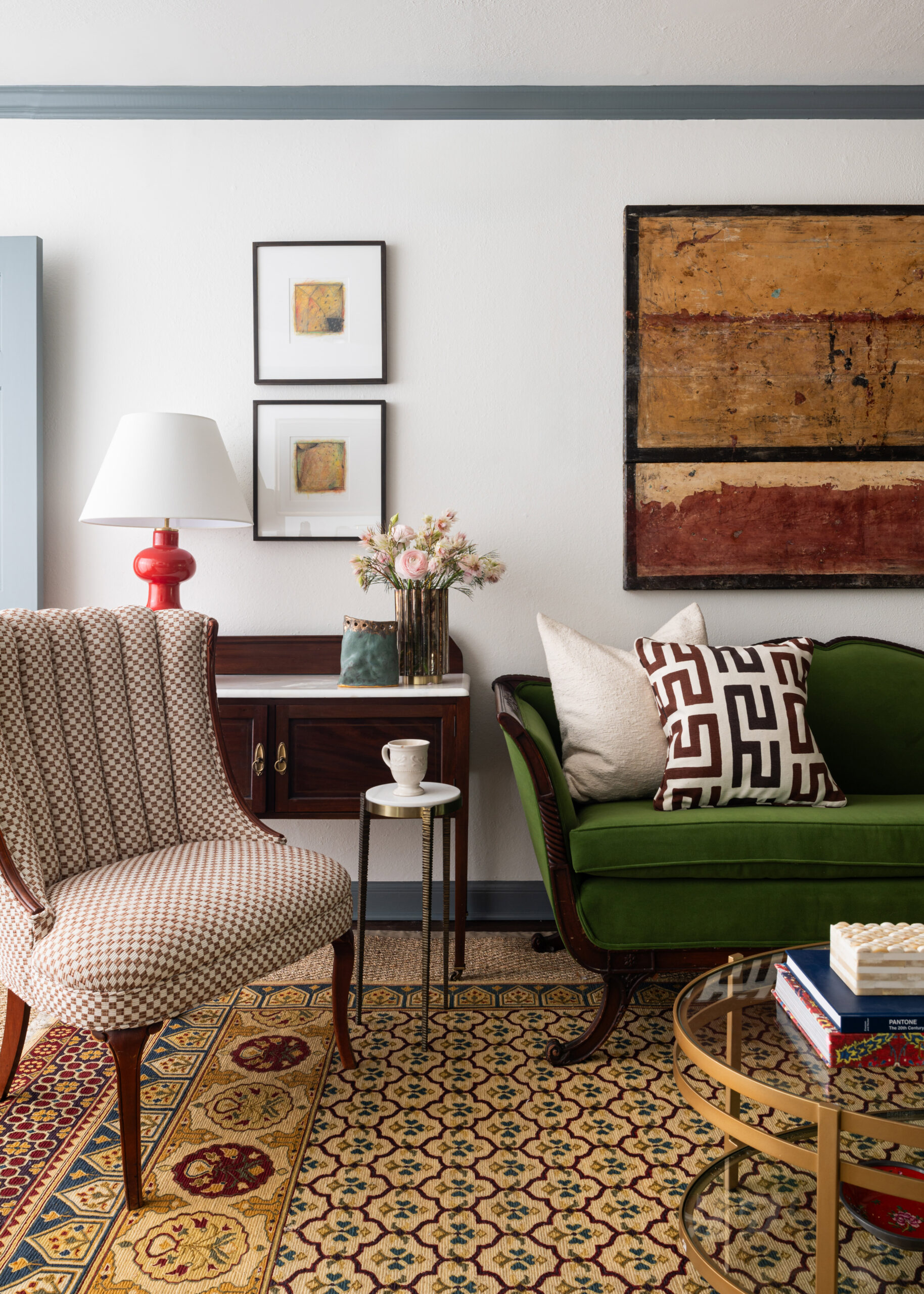 A sophisticated living room with stylish green chairs and a curated display of artwork. The room showcases elegant interior design and photography.