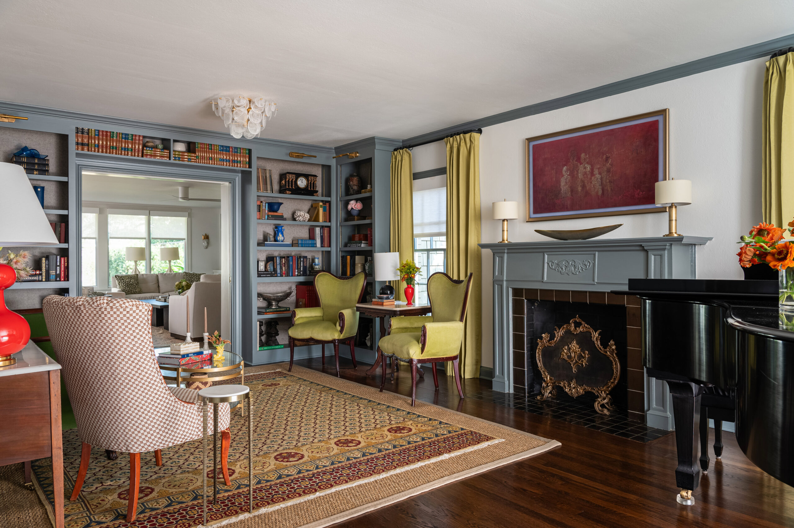 The combination of green chairs and open bookshelves adds character to the living room. Interior design and photography bring the traditional yet bold design to life.