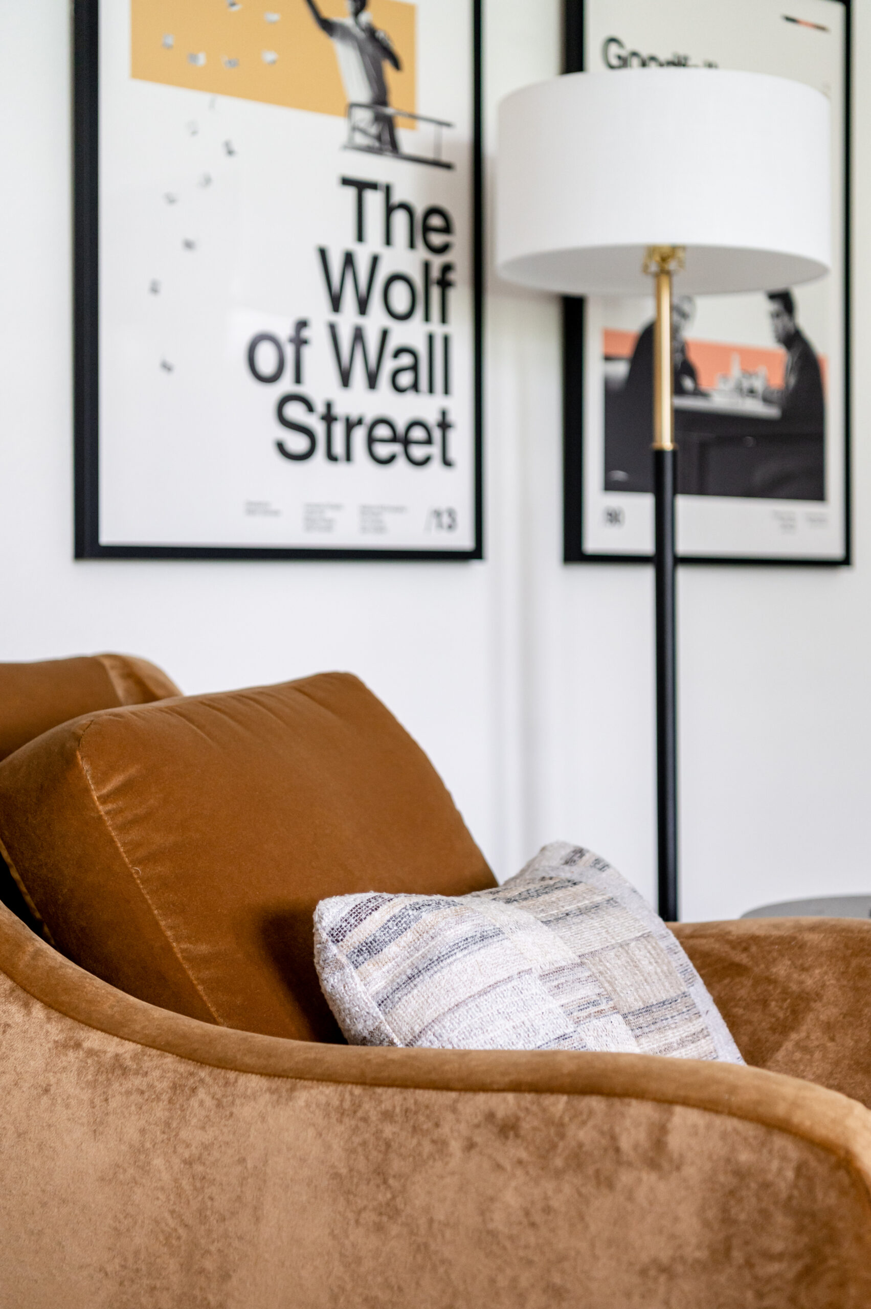 A modern sectional with deep green tones and contrasting pillows, paired with geometric artwork and vibrant decor