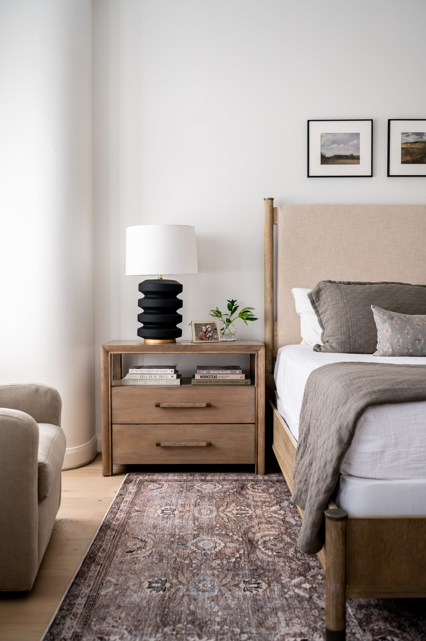 Neutral-toned bedroom with a modern bedside lamp and a cozy setting.
