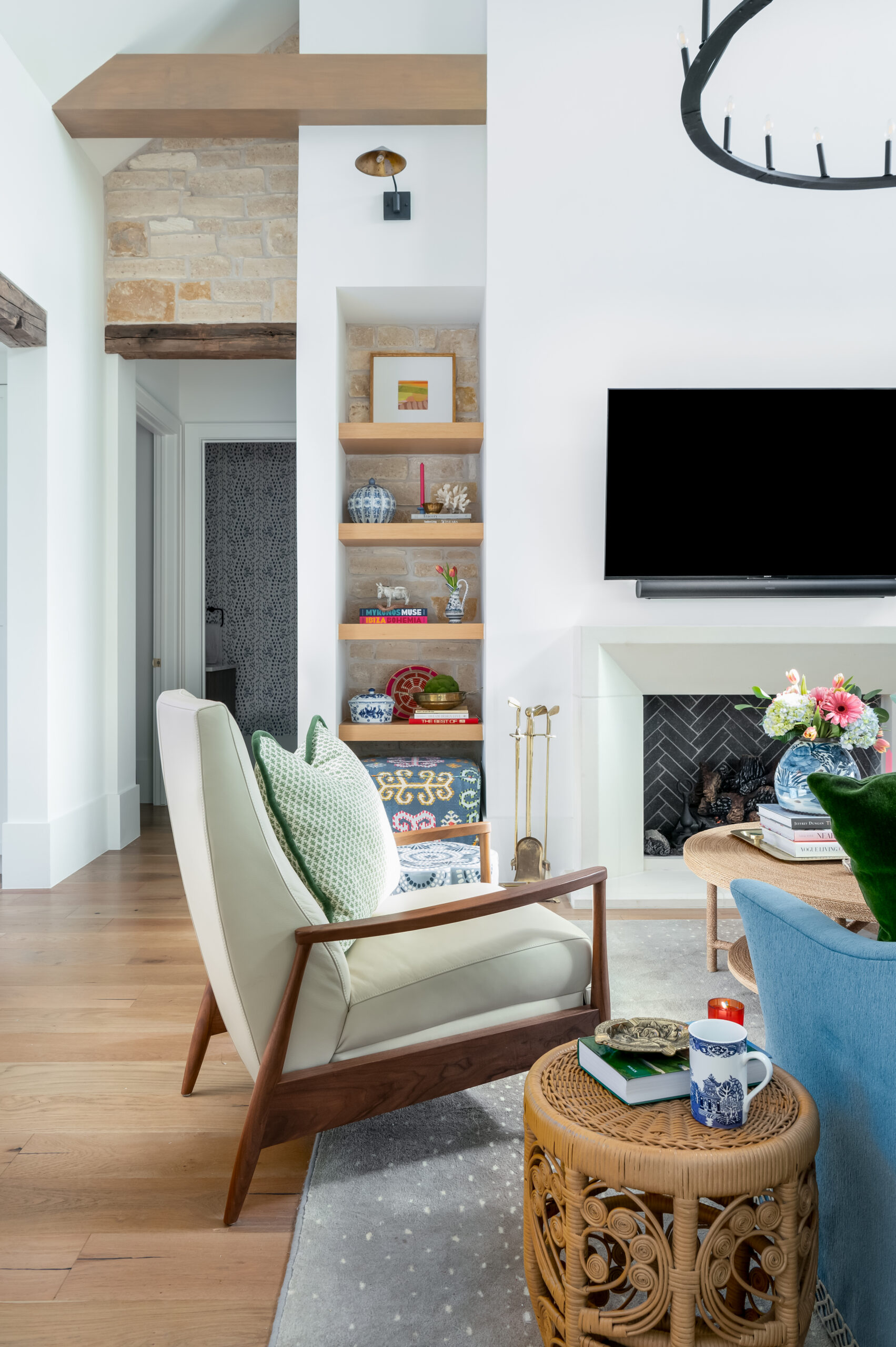 Image of a living room with a neutral sofa, intricate rug, and green plants on the coffee table.