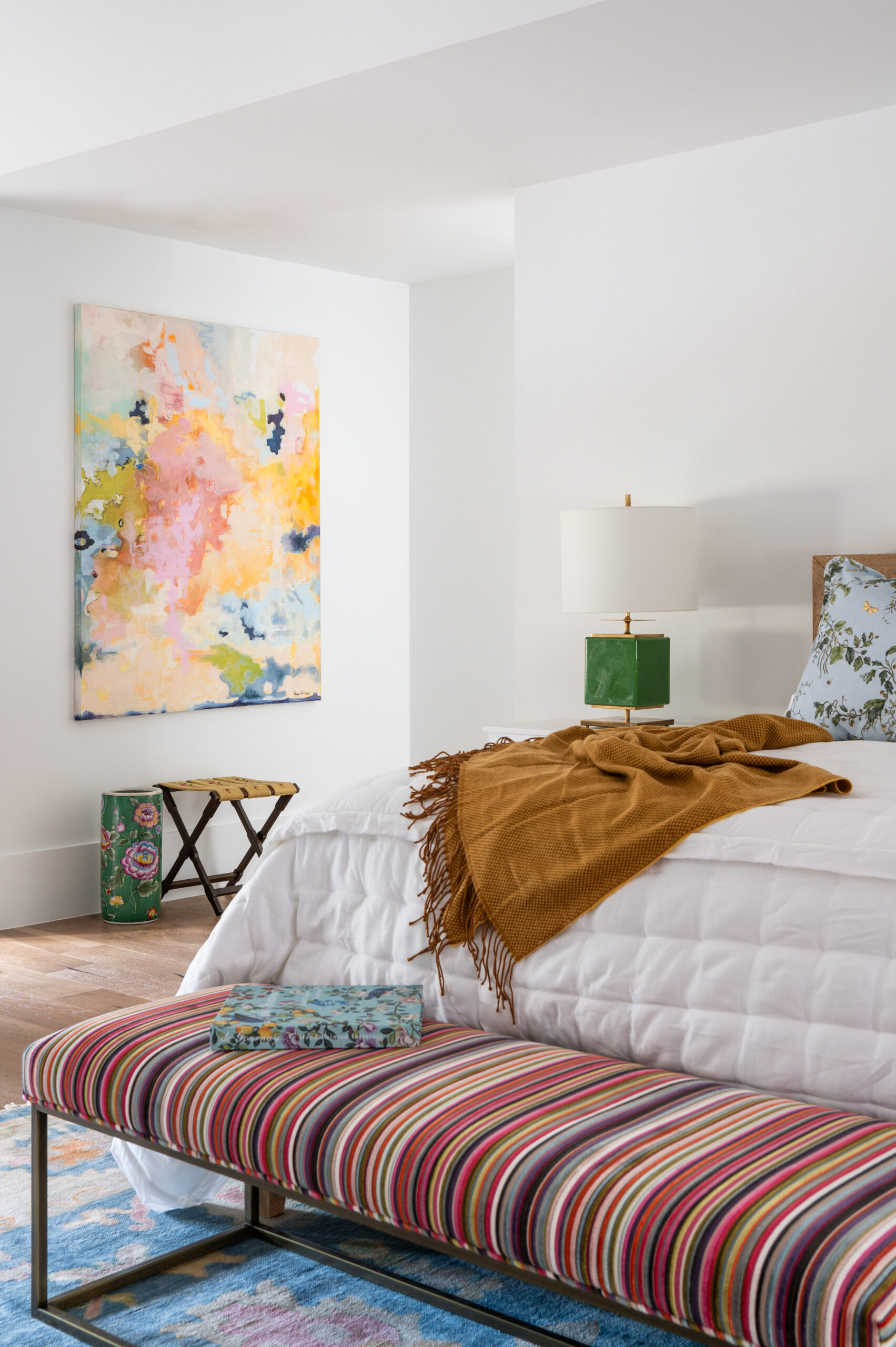 Close-up of a bedroom with textured artwork and pillows with a vintage feel.
