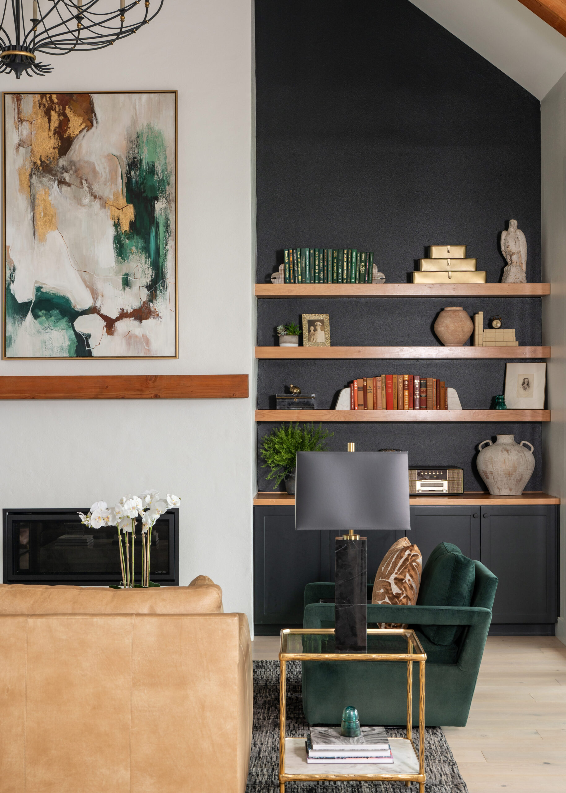 A beautiful modern living space with green velvet chairs and stylish art decor on the shelves, encapsulating a modern home interior design aesthetic.