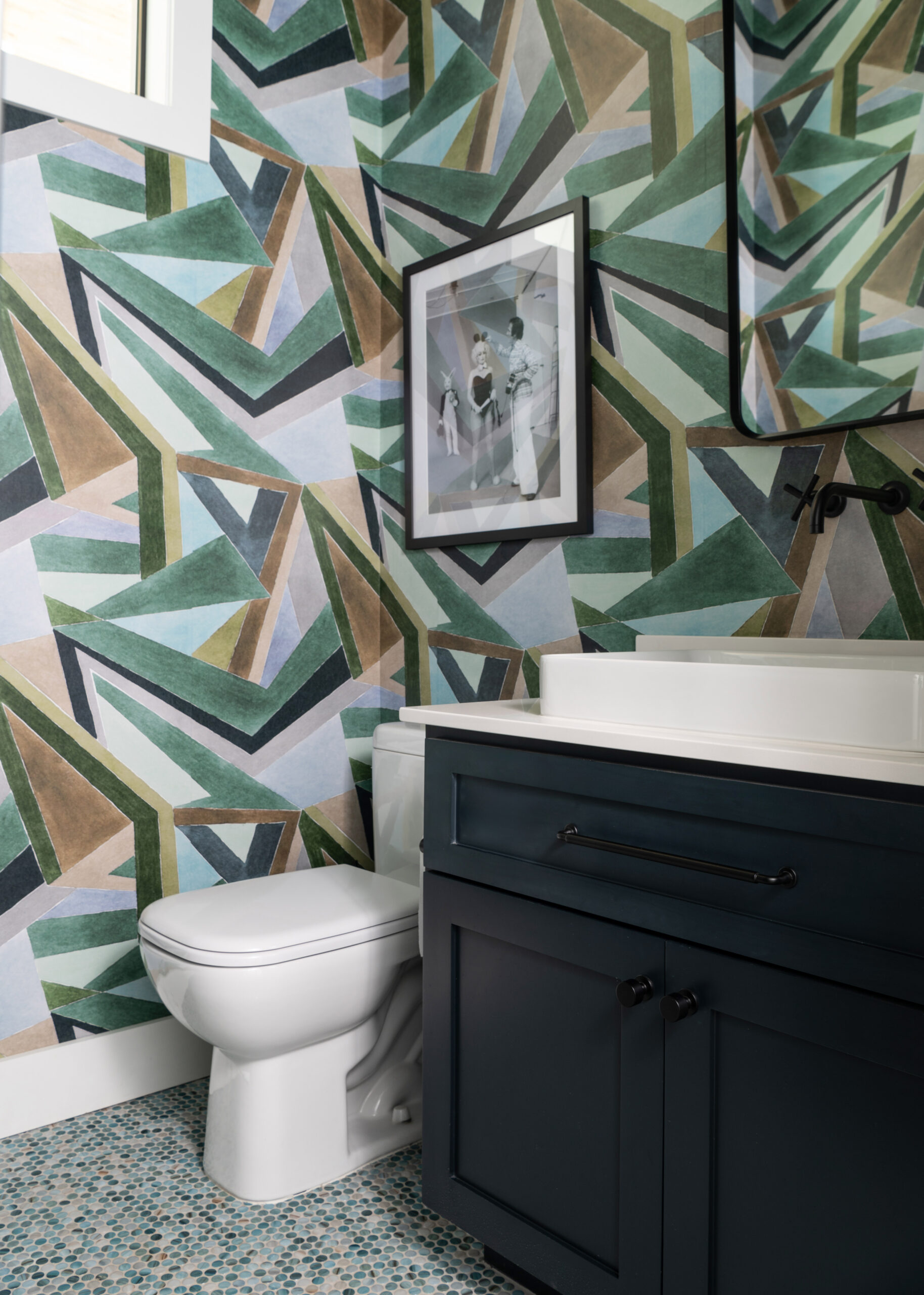 Chic modern bathroom with geometric patterned wallpaper, dark cabinetry, and a clean white sink, bringing a sophisticated look to the space