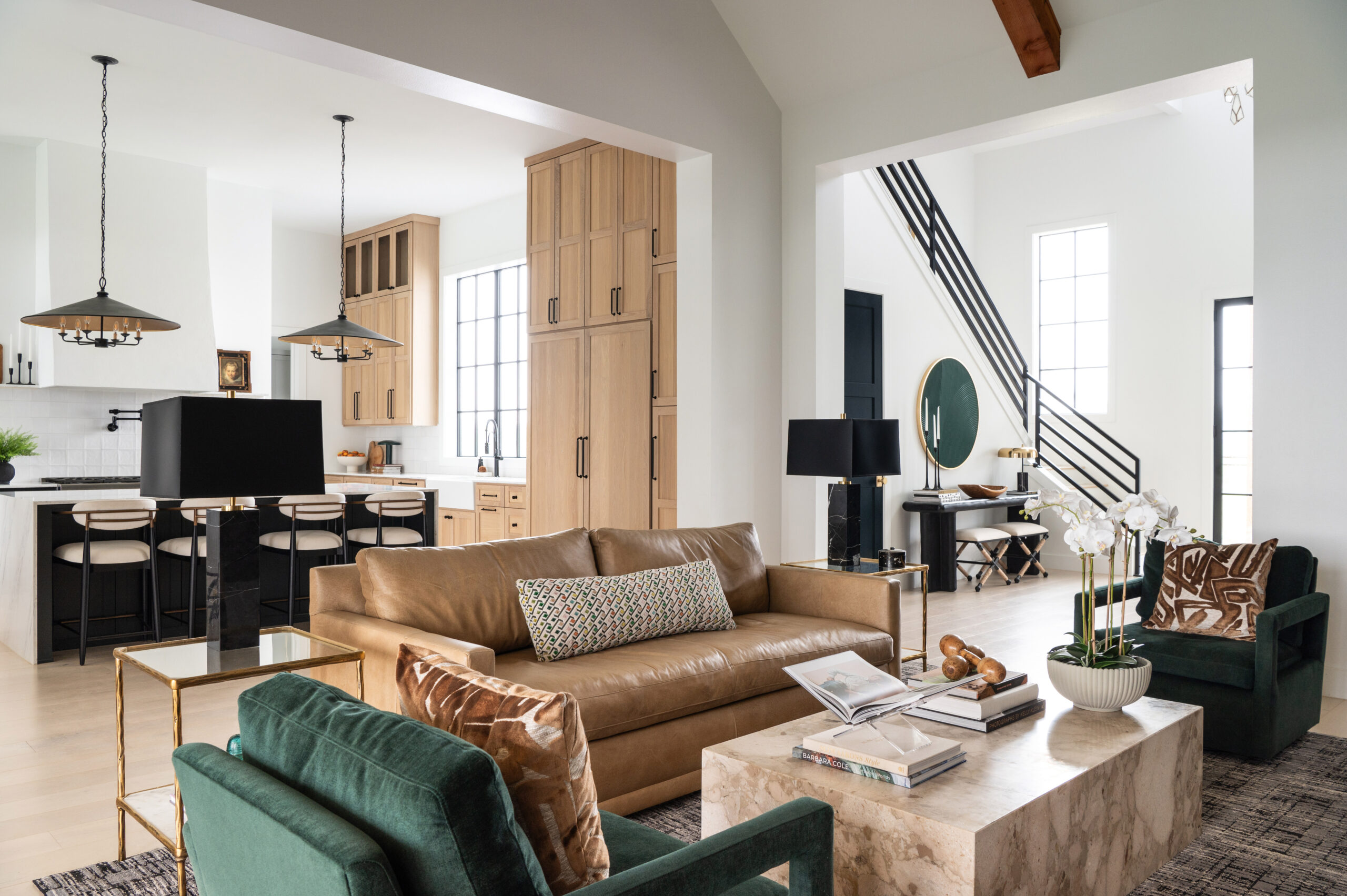 A beautiful modern living space with green velvet chairs and stylish art decor on the shelves, encapsulating a modern home interior design aesthetic.