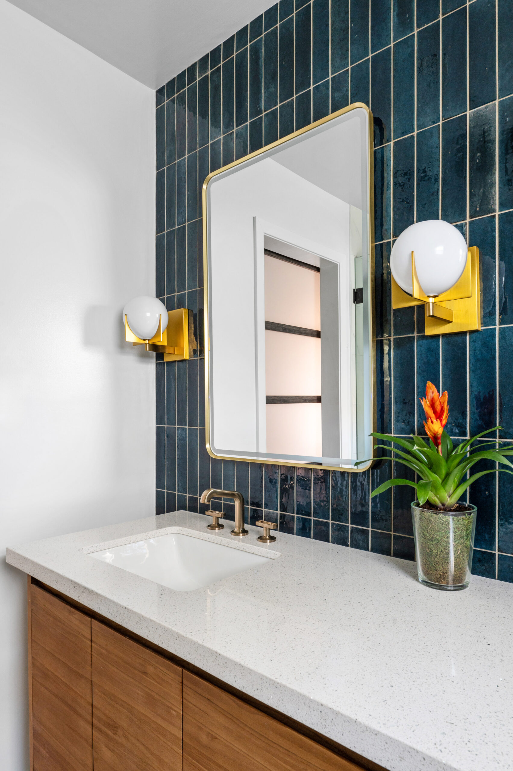 A bathroom featuring sleek tilework with a striking dark green backsplash and minimalist gold lighting. Perfect for modern interior design publications looking to showcase bold, unique bathrooms.


